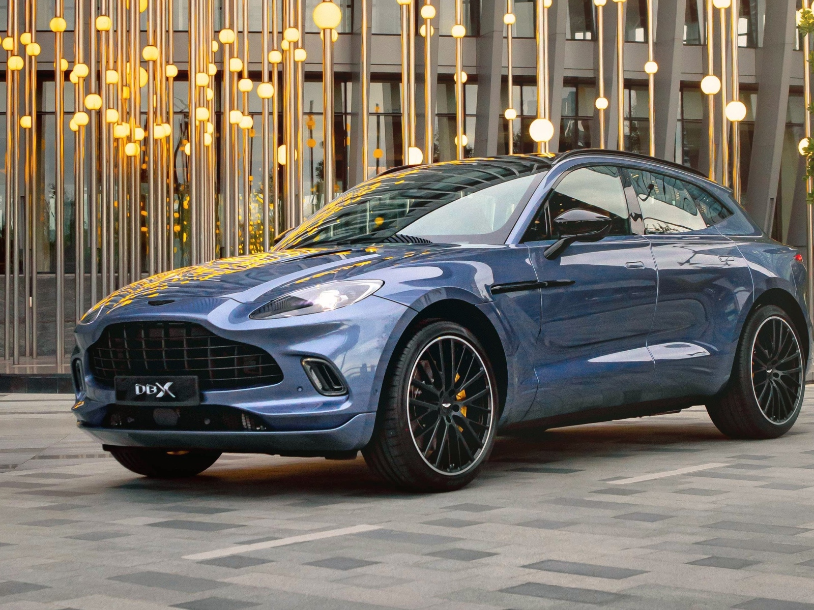 Автомобиль Aston Martin DBX у здания