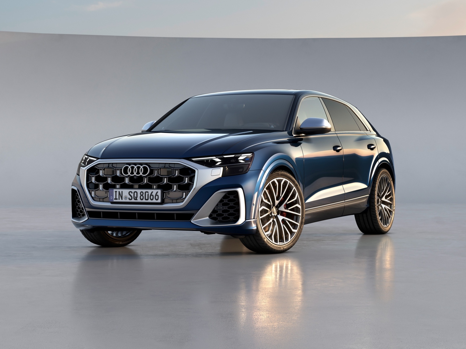 Синий автомобиль Audi SQ8 TFSI 2023 года на сером фоне