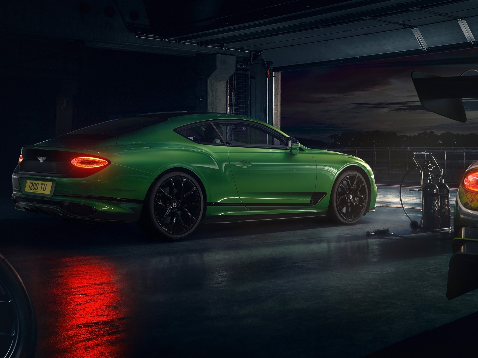 Зеленый автомобиль Bentley Continental GT S на заправке