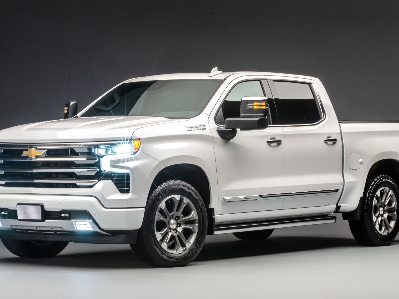 Белый дорогой пикап Chevrolet Silverado 2023 года на сером фоне