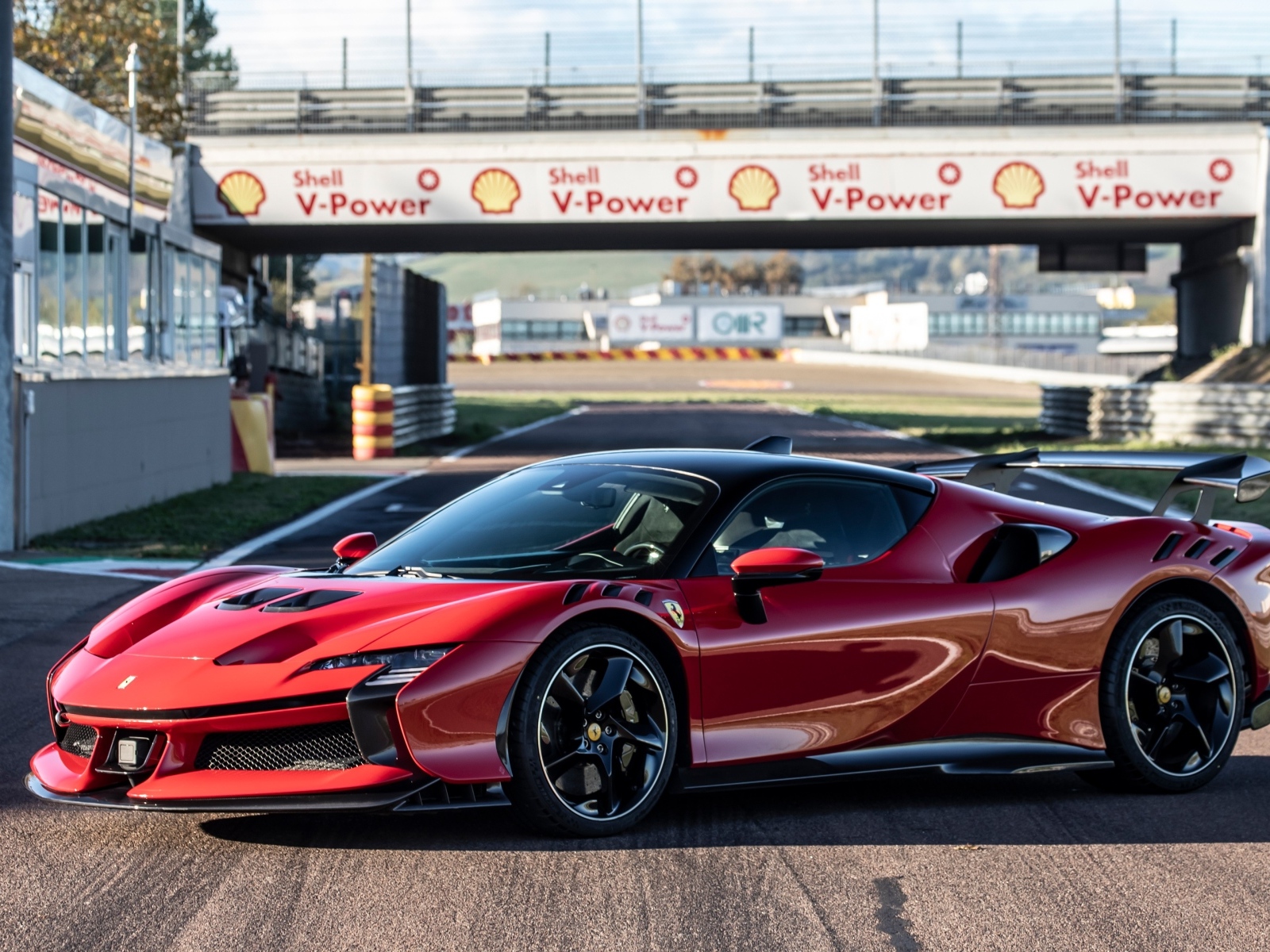 Красный автомобиль Ferrari SF90 XX Stradale на стадионе