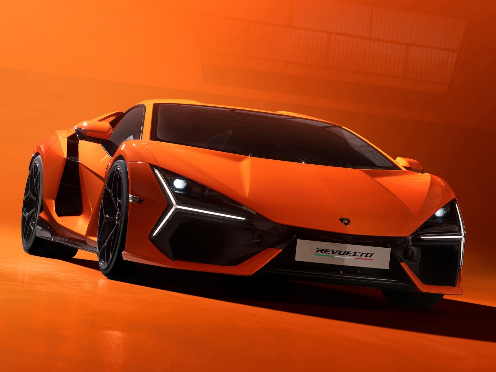 Спортивный автомобиль Lamborghini Revuelto 2023 года на красном фоне