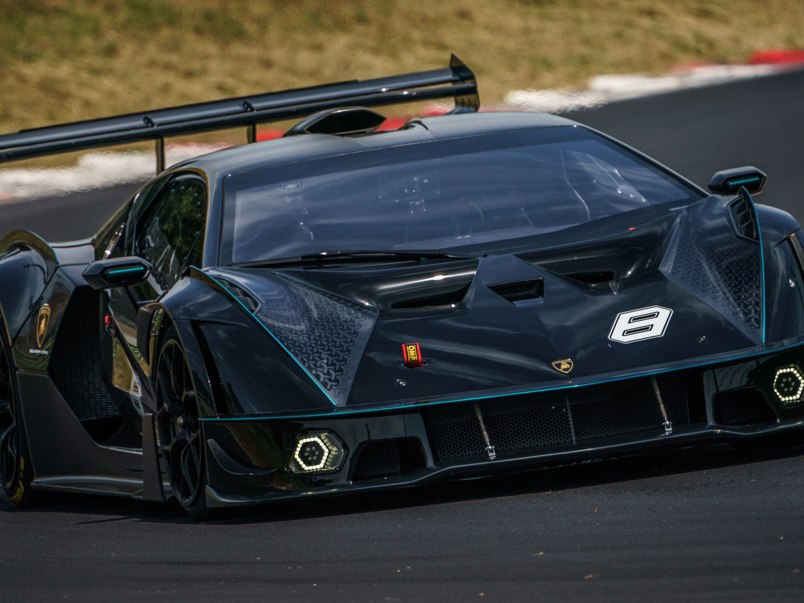 Черный спортивный Lamborghini Essenza SCV12 на гоночной трассе 