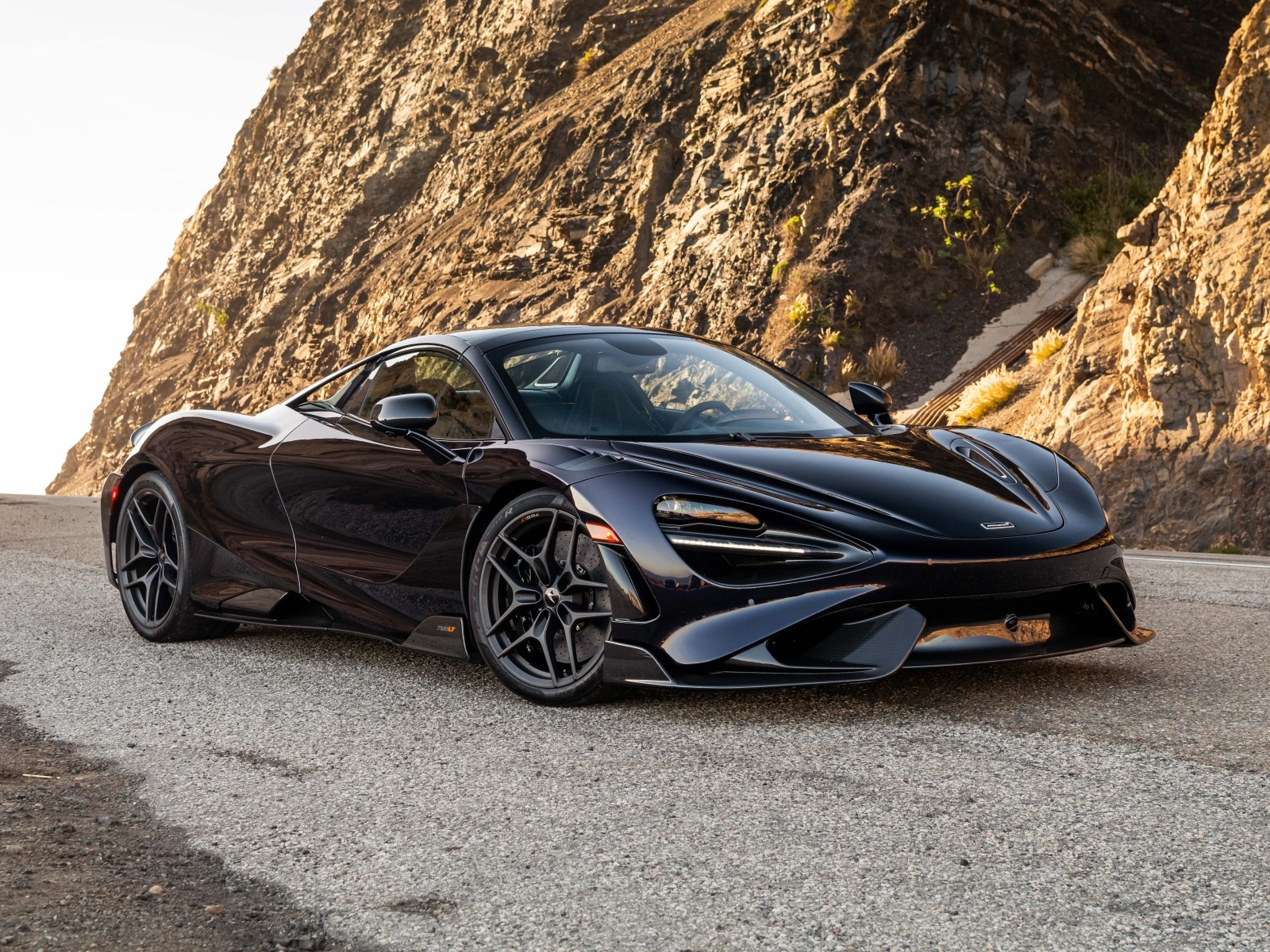 Черный спортивный автомобиль McLaren 765LT Spider у гор