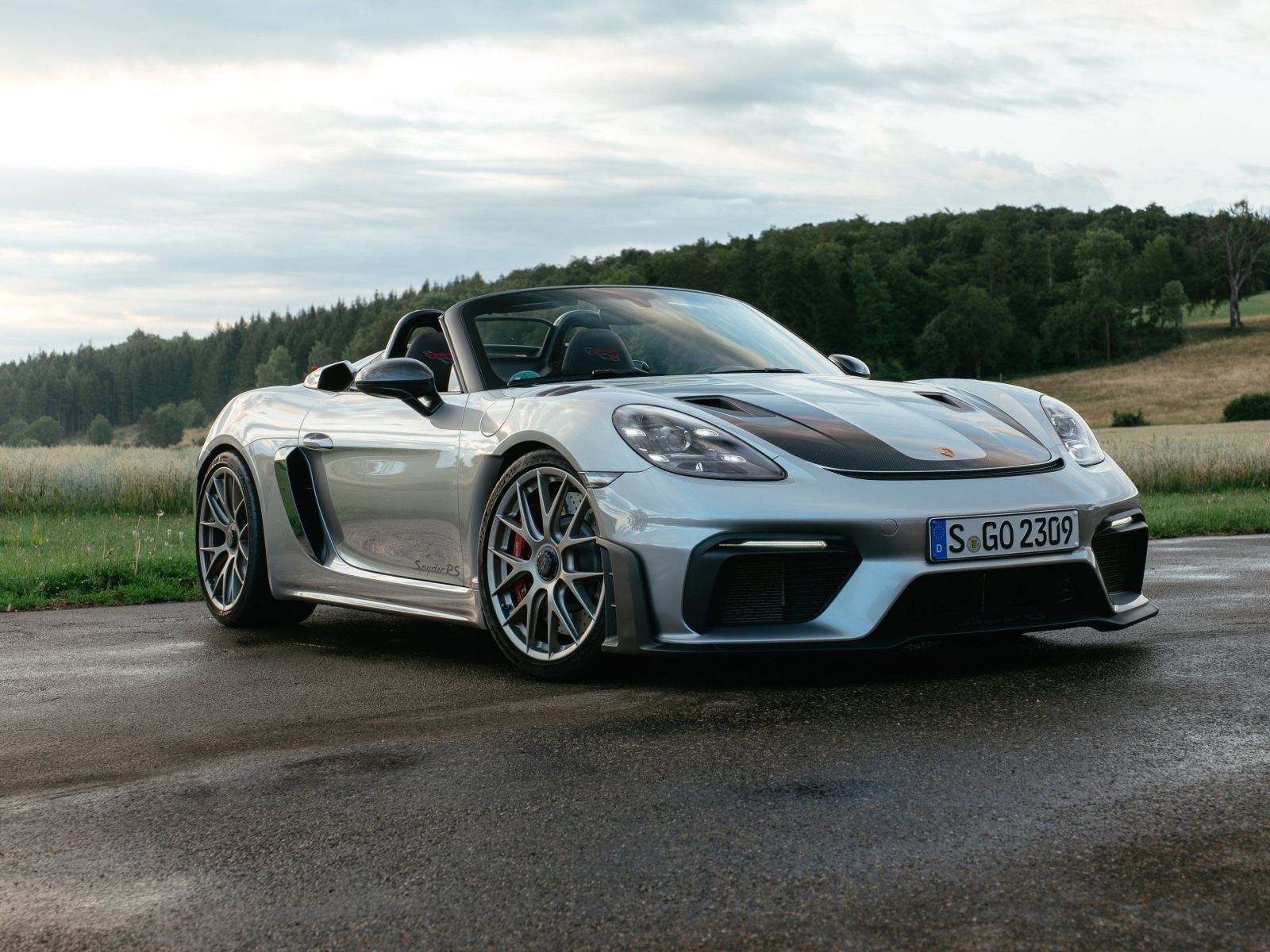 Быстрый Porsche 718 Spyder RS на мокрой дороге