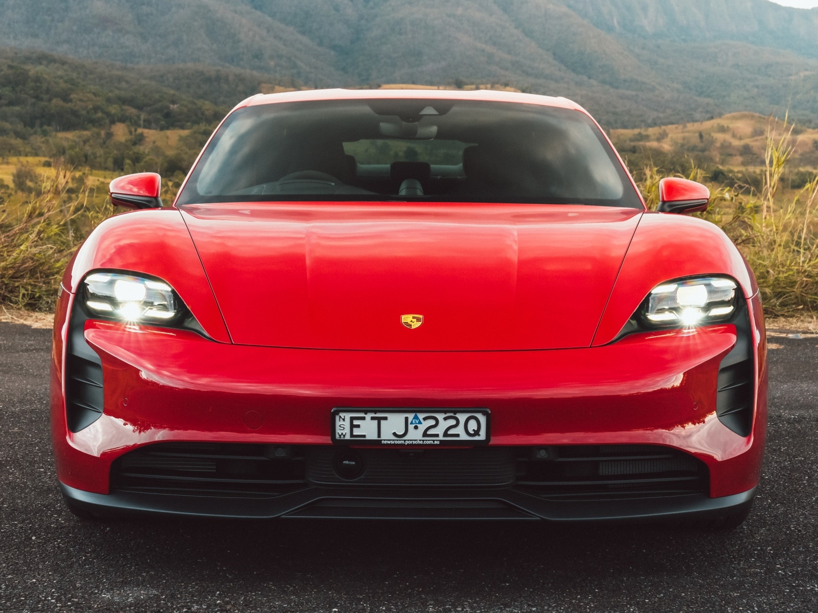 Красный автомобиль Porsche Taycan GTS вид спереди