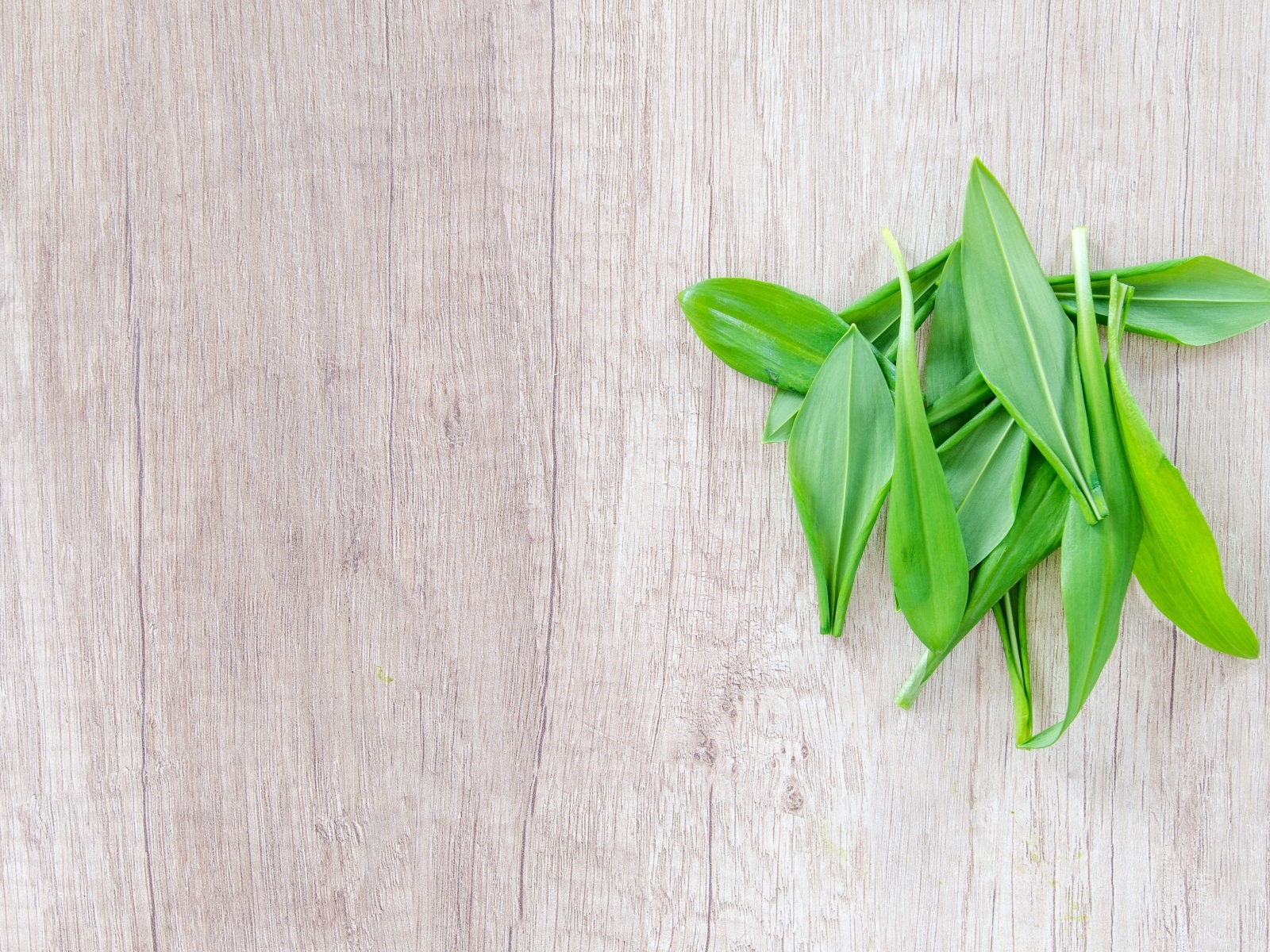 Пучок зеленых листьев на деревянной поверхности 