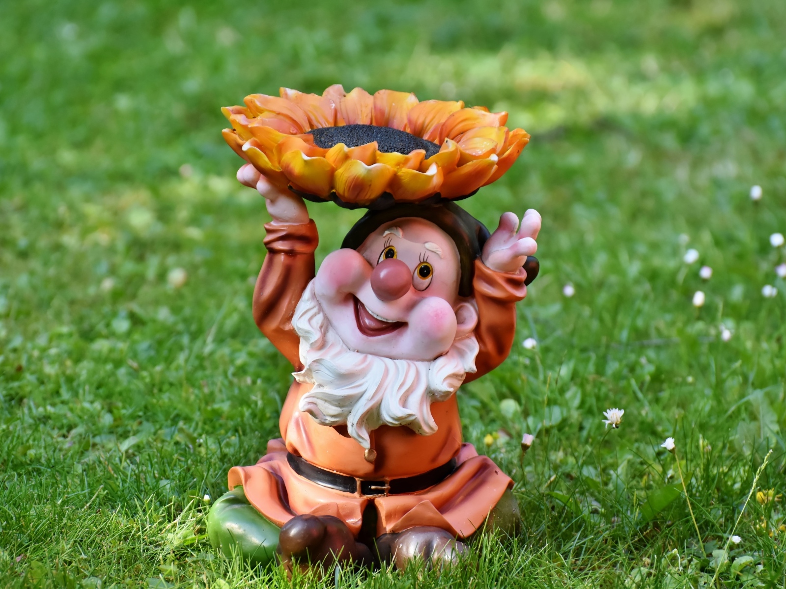 Садовая фигура гном за зеленой траве