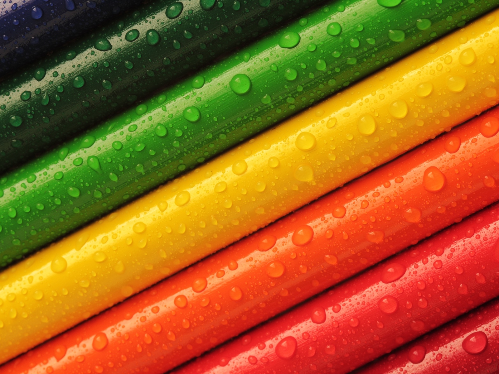 Разноцветные карандаши в каплях воды