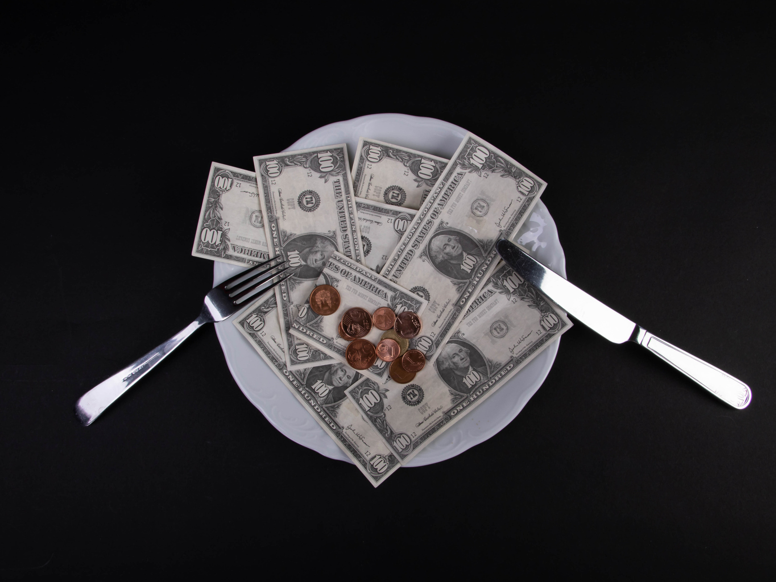 Тарелка с долларами на черном фоне