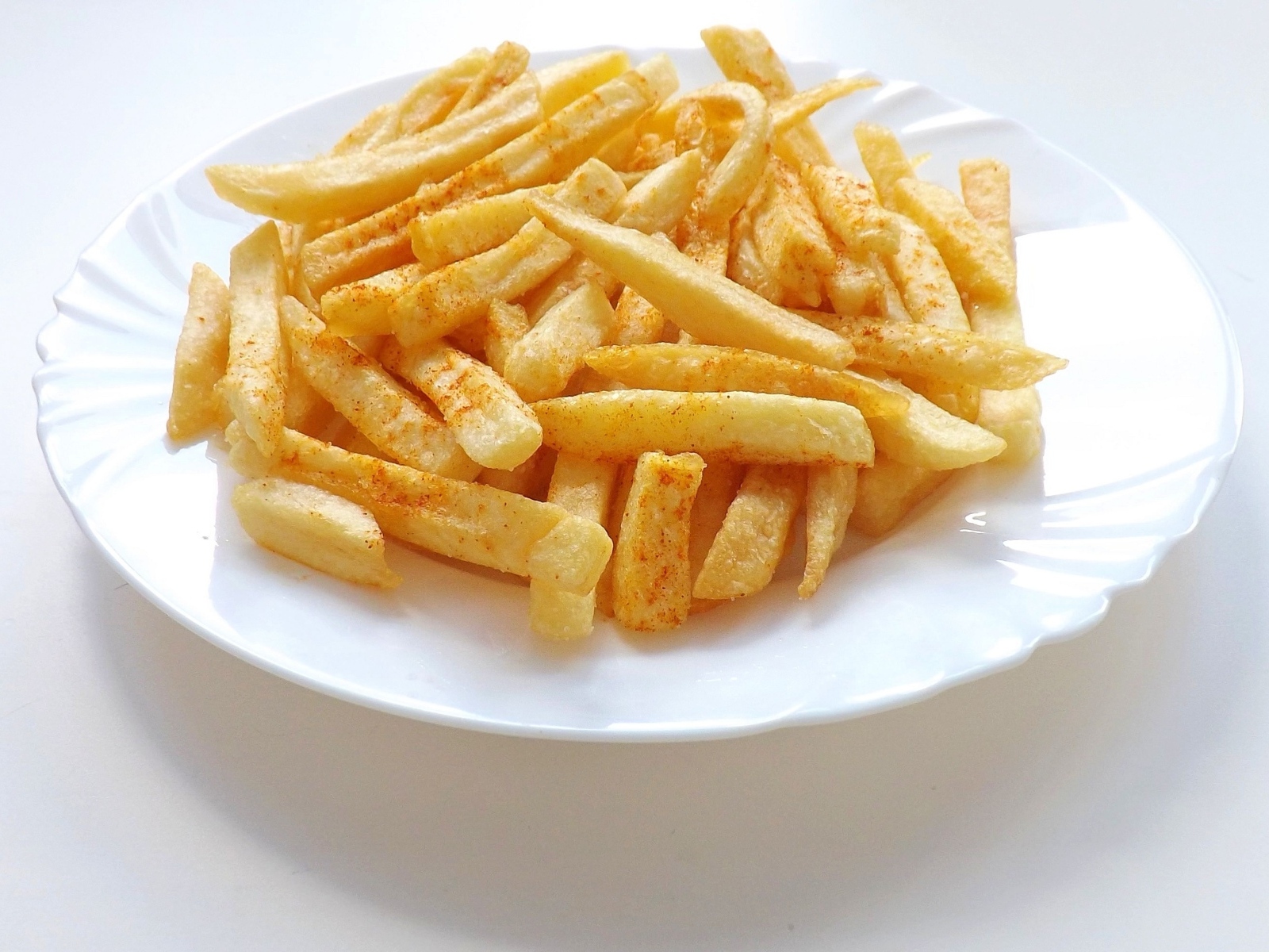 Картофель фри на большой белой тарелке