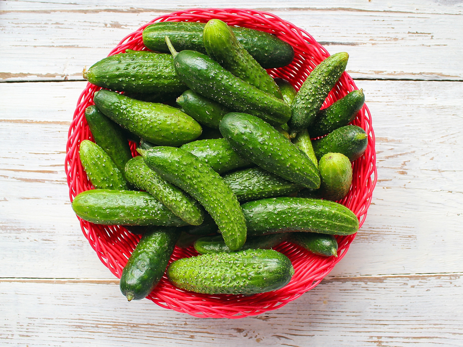 Свежие зеленые огурцы в корзинке на столе