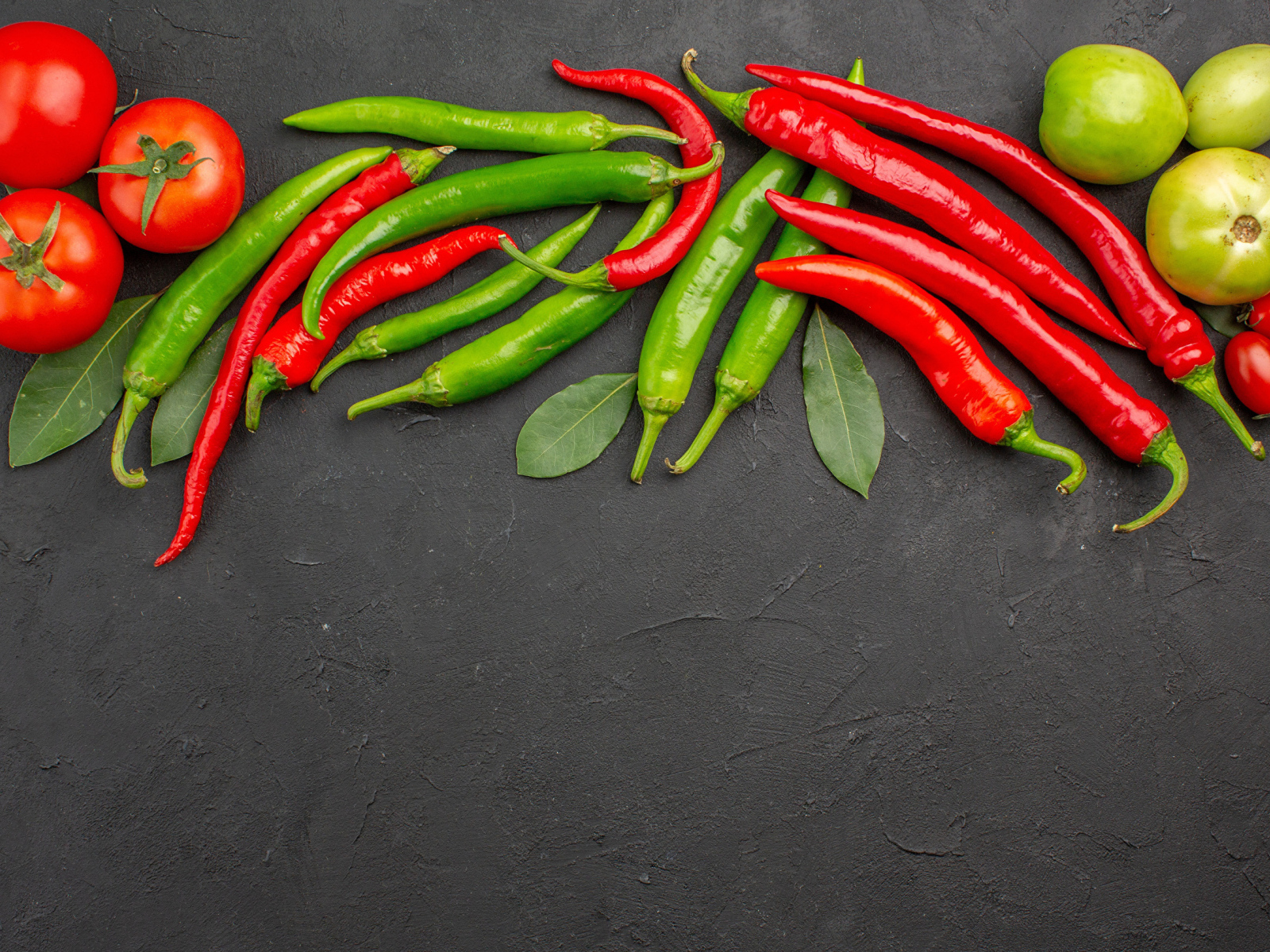 Острый перец чили на столе с помидорами