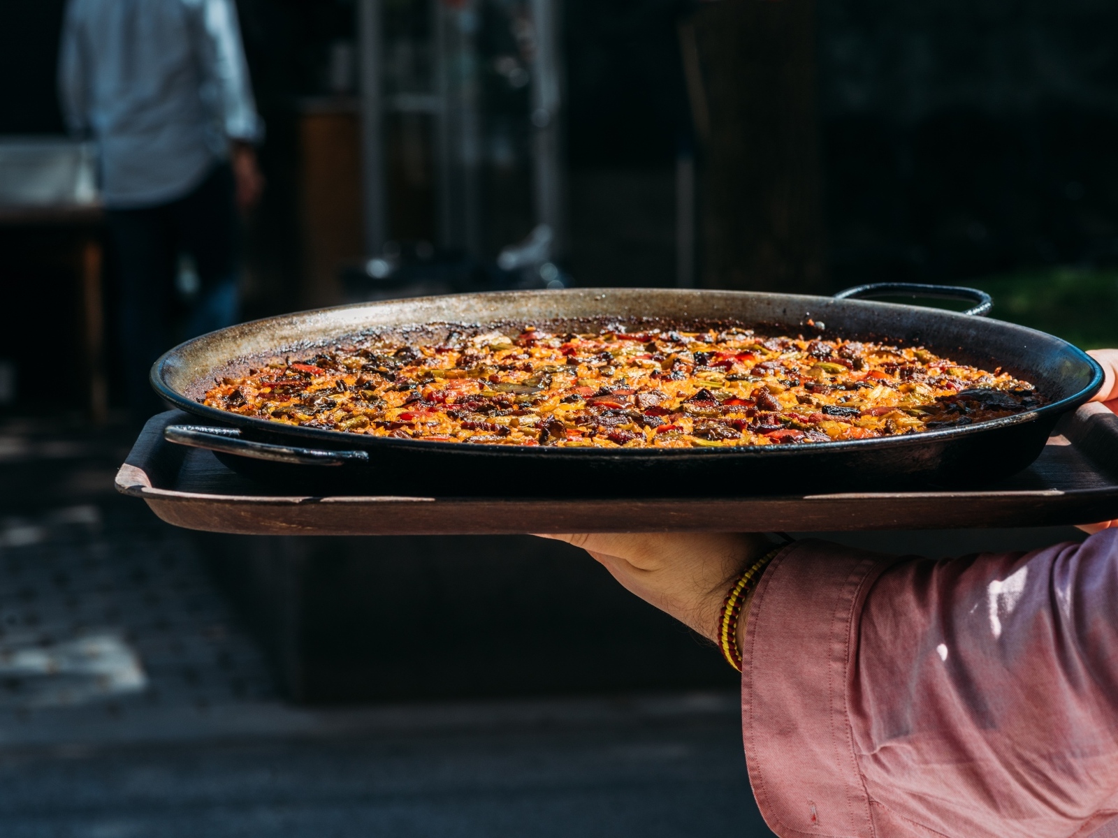 Блюдо паэлья в руках 