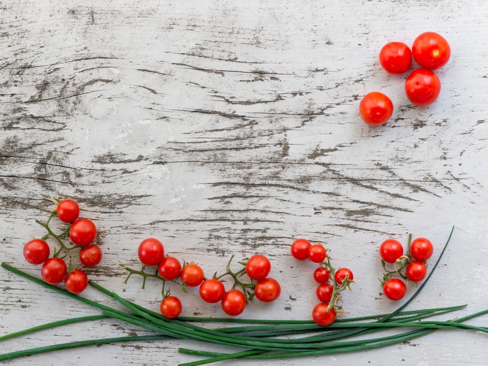 Красные помидоры с зеленым луком на деревянном столе