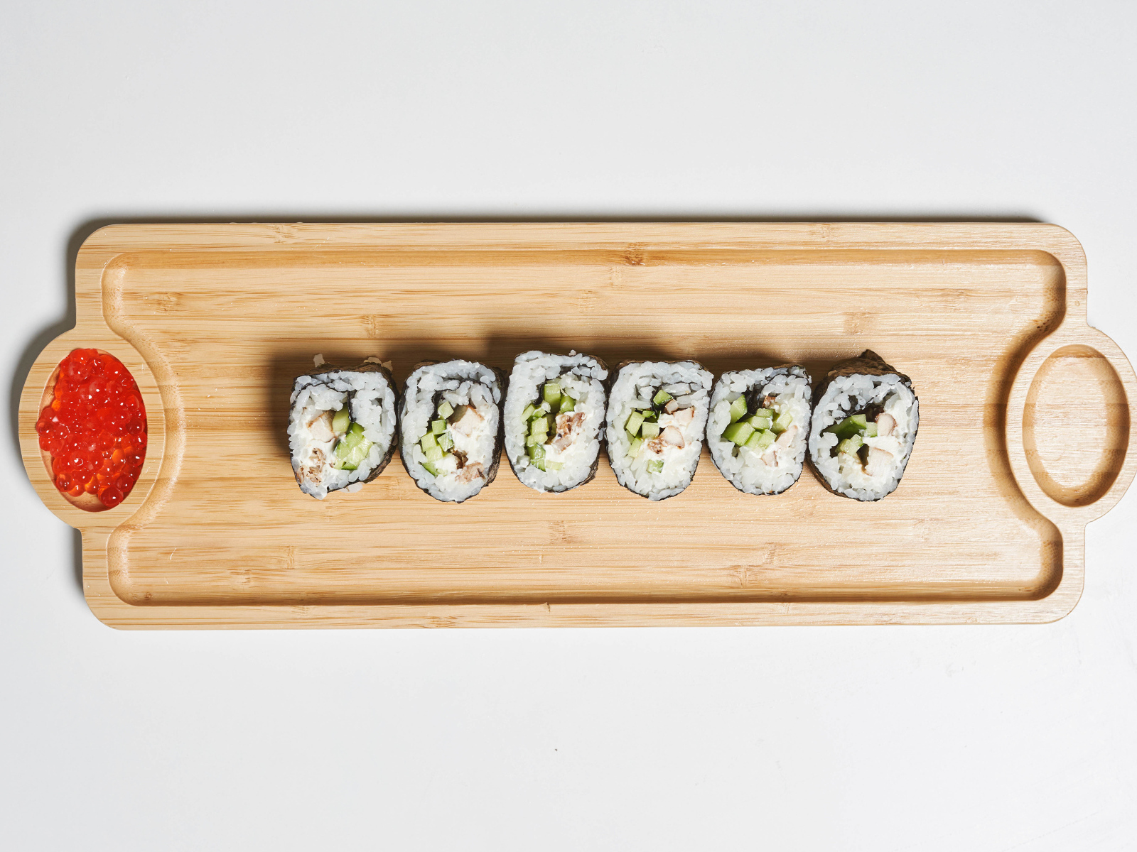 Суши на деревянной доске с  красной икрой