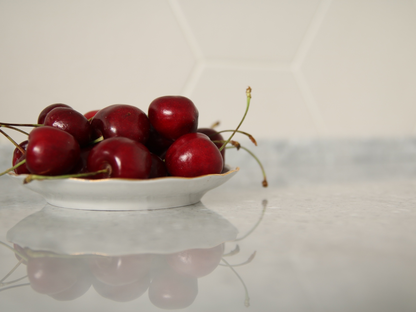 Вкусные сладкие черешни на белой тарелке