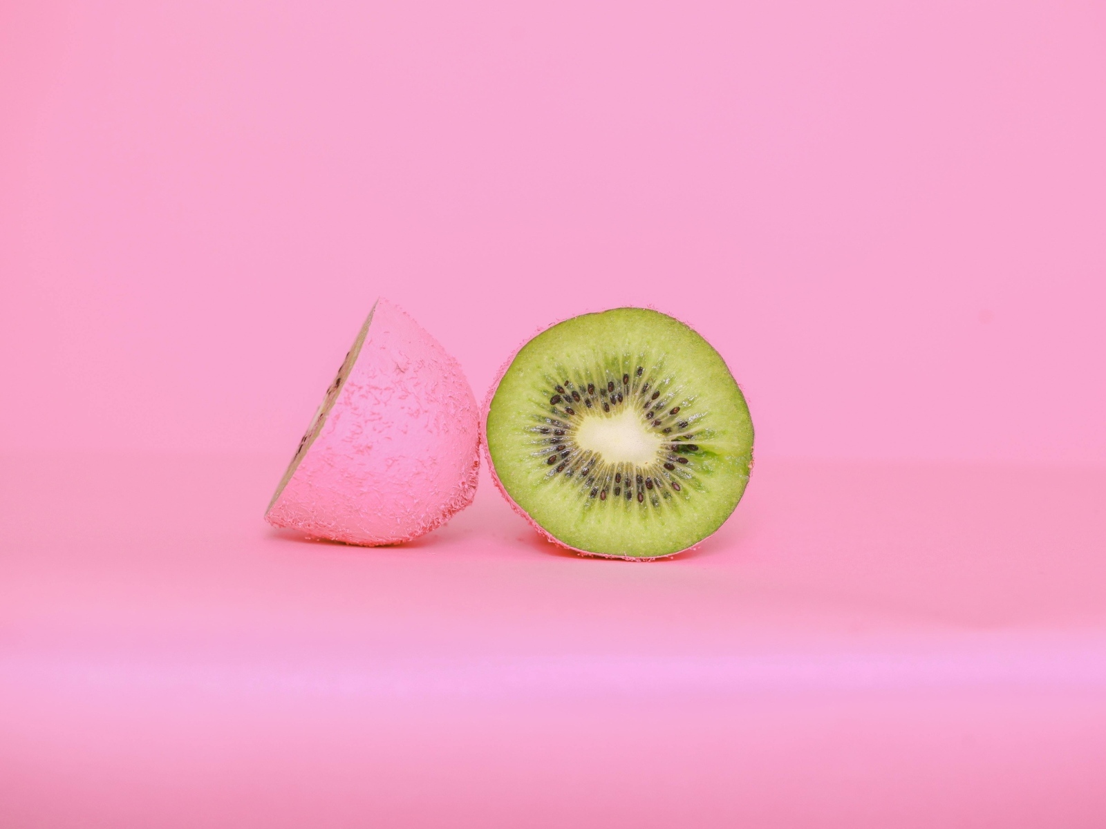 Половинки киви на розовом фоне