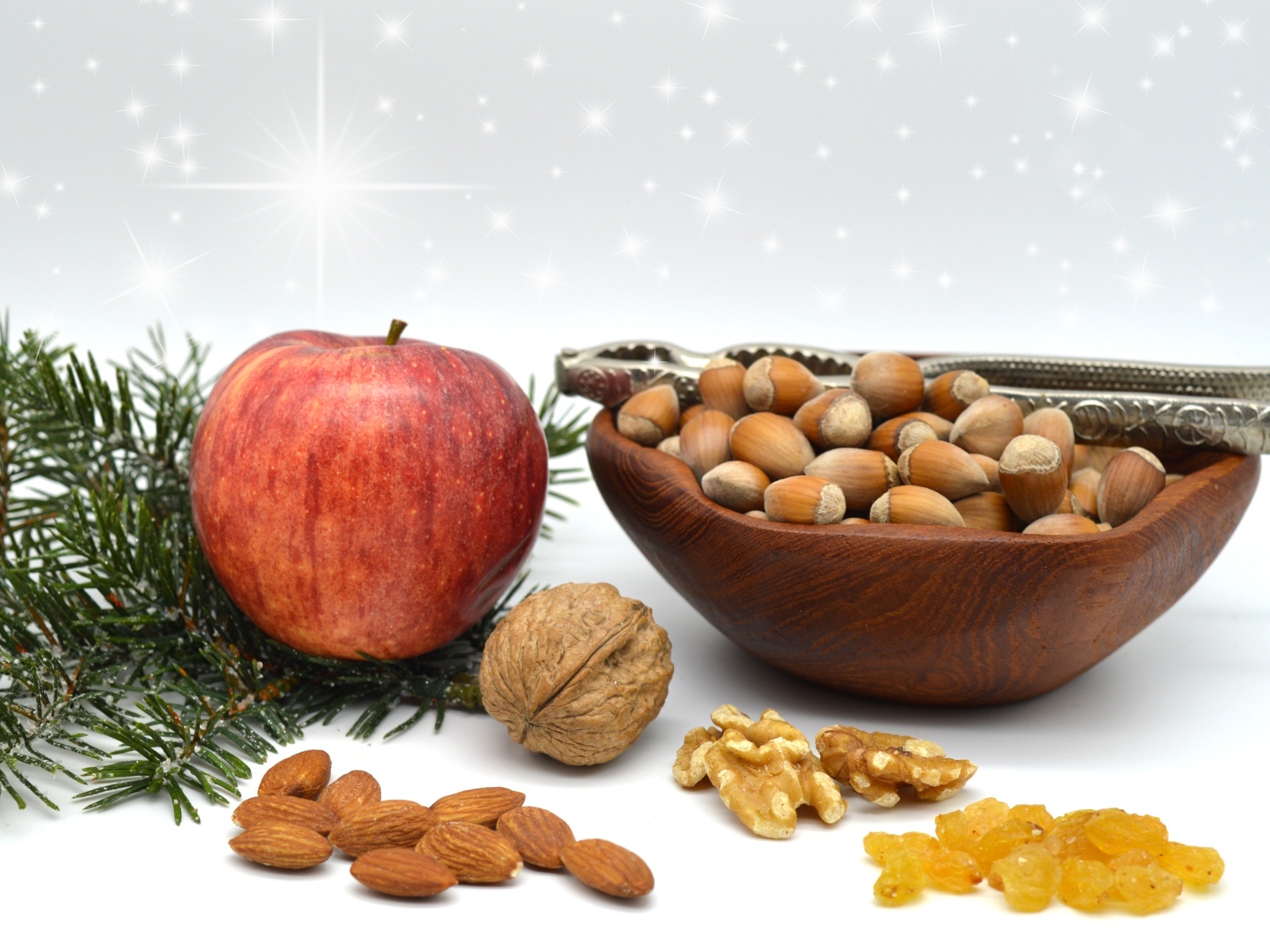 Орехи с яблоком и еловой веткой на столе