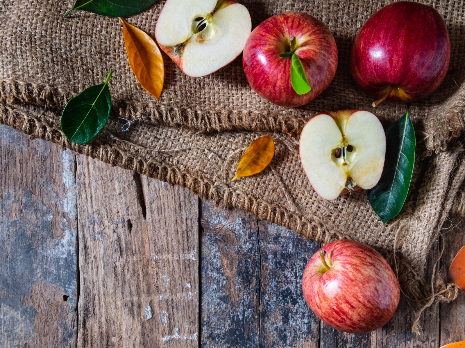 Спелые красные яблоки на столе с мешком