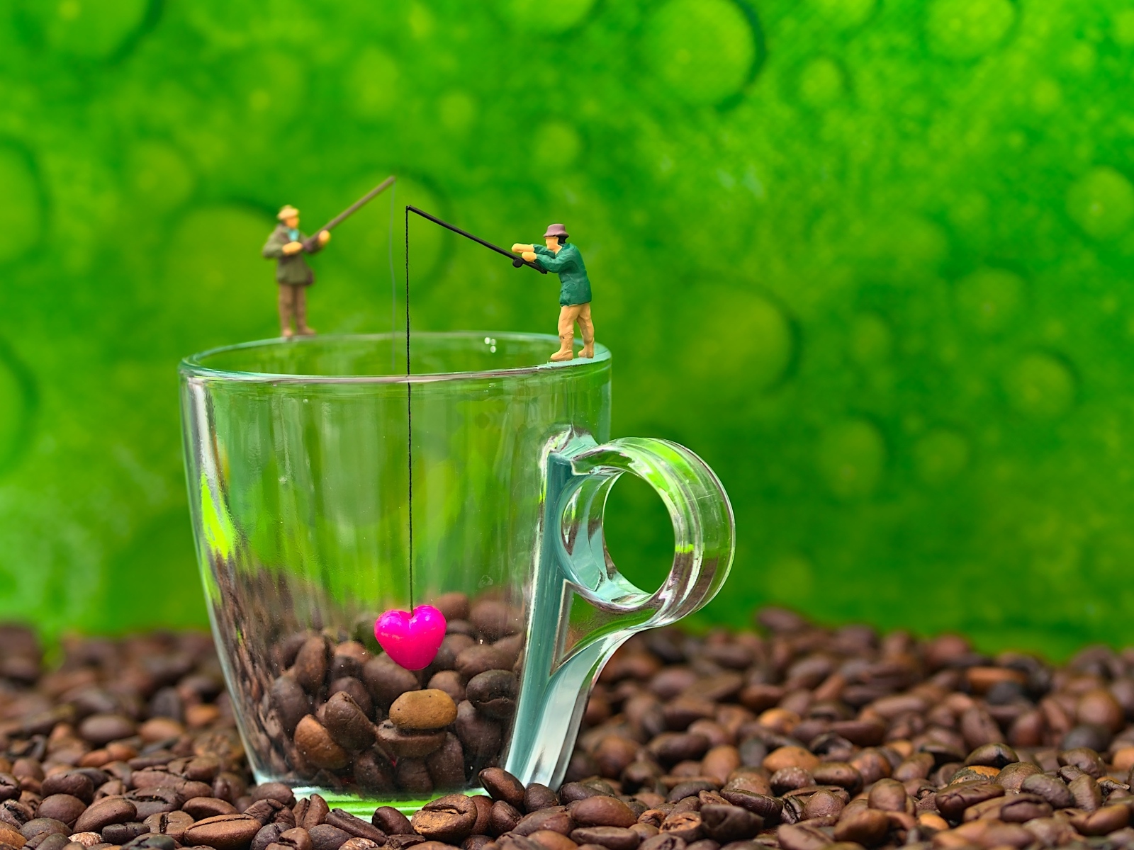 Две фигурки на стеклянной чашкой с кофейными зернами