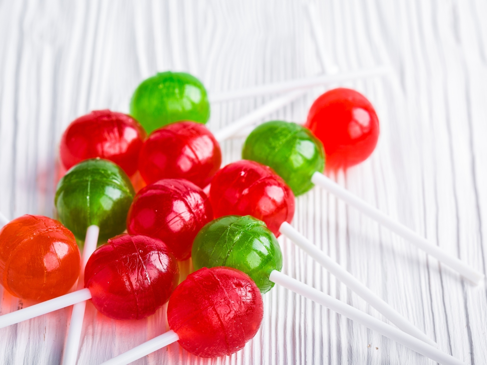 Разноцветные леденцы на палочке лежат на столе