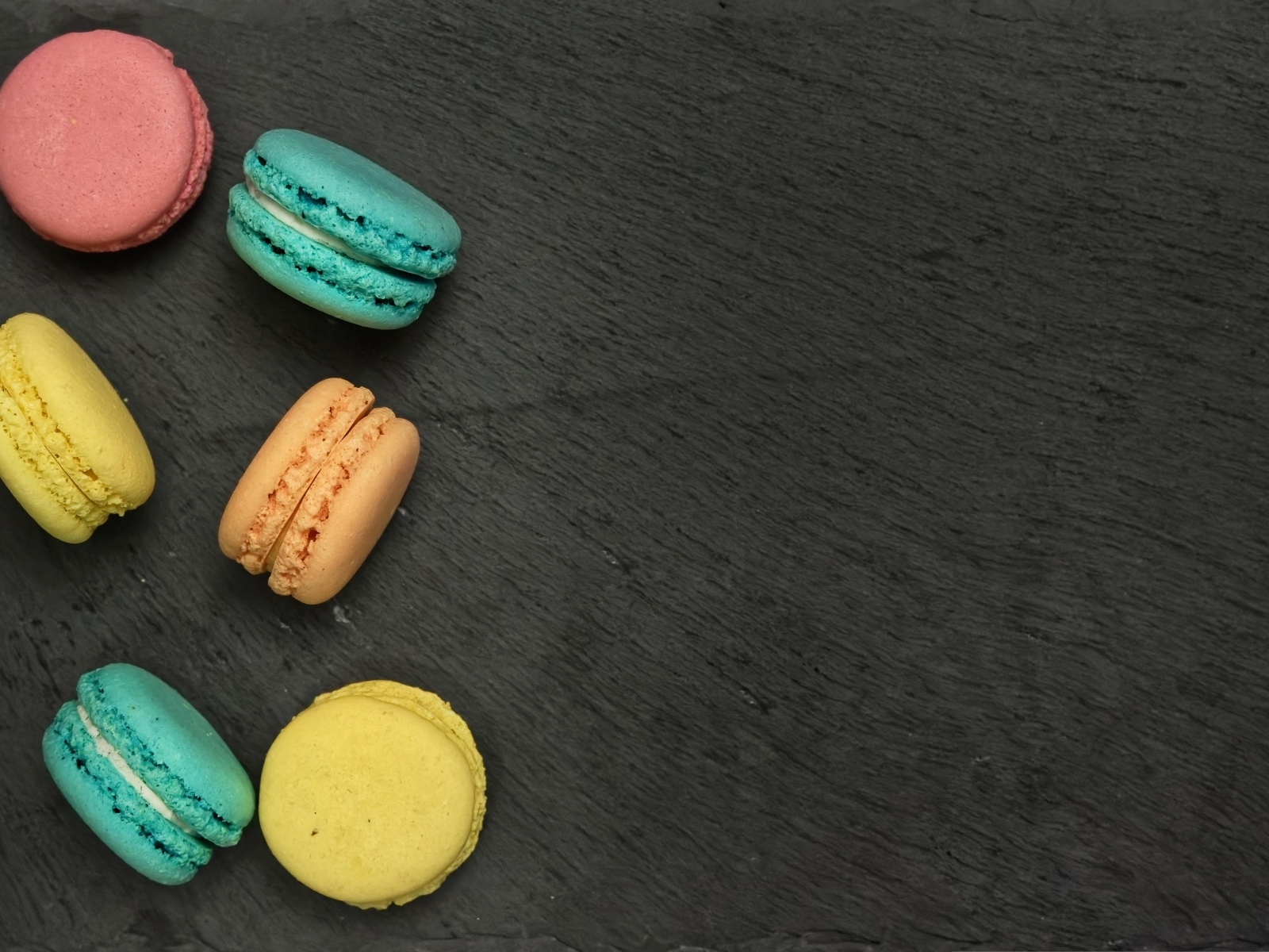 Разноцветный десерт макарон на сером столе