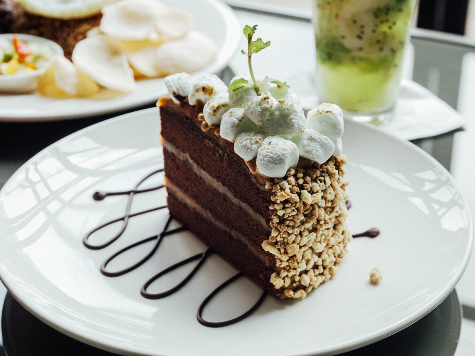 Кусок шоколадного торта с маршмеллоу на белой  тарелке