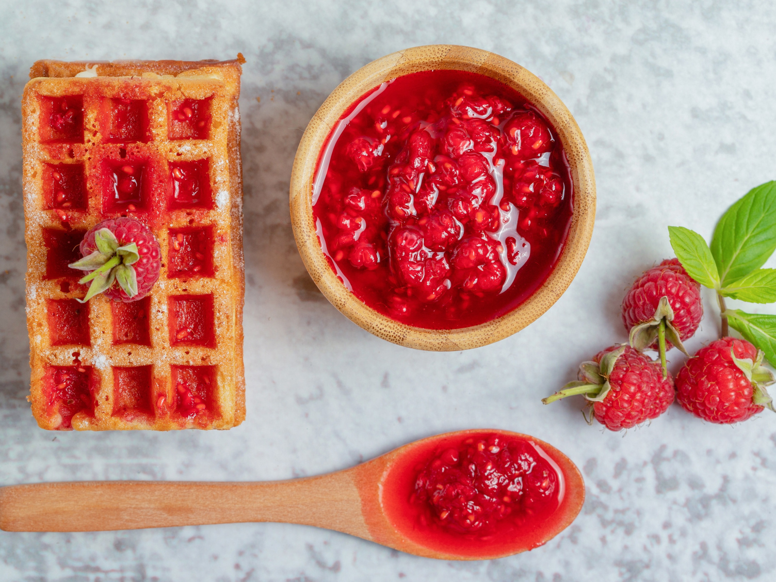 Сладкие вафли с малиновым вареньем и ягодами на столе
