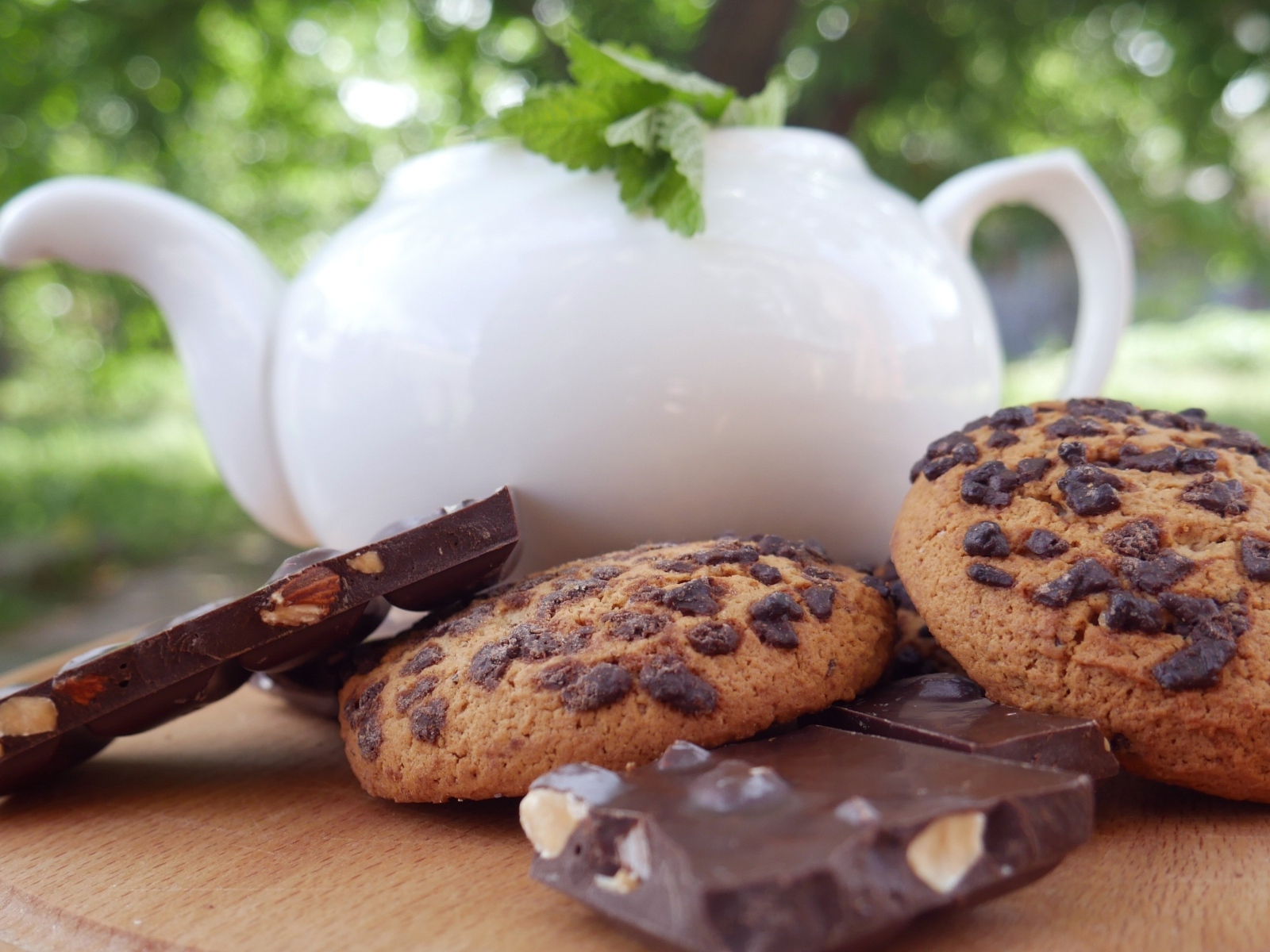 Чайник на столе с печеньем и шоколадом