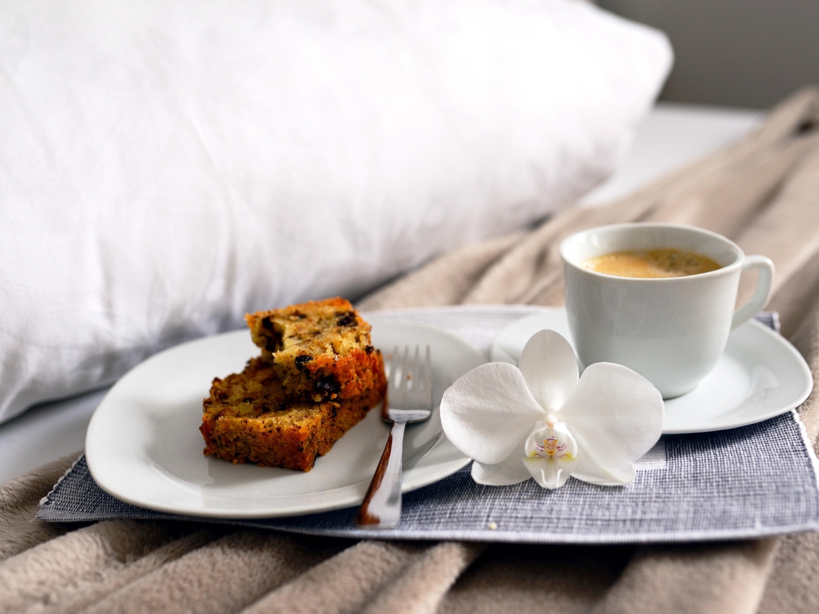 Чашка кофе с цветком орхидеи и кусочками кекса