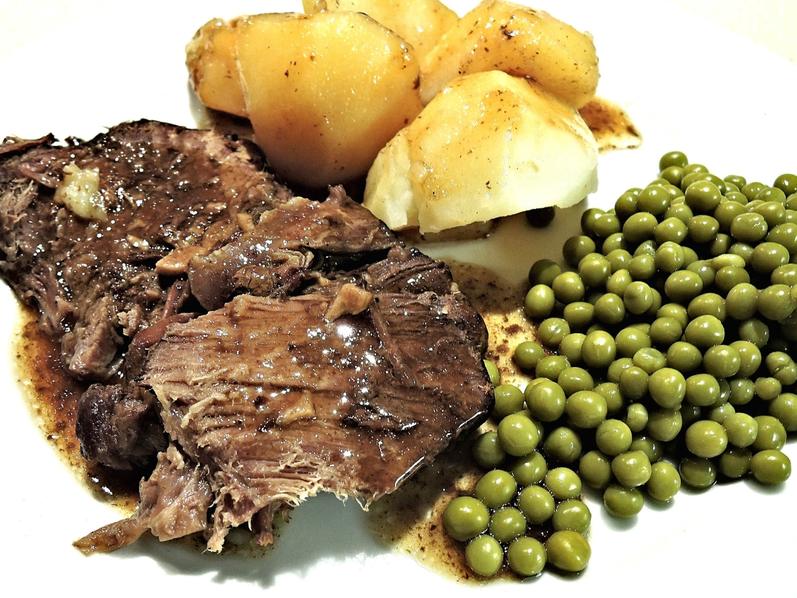 Кусок мяса с картофелем и зеленым горошком