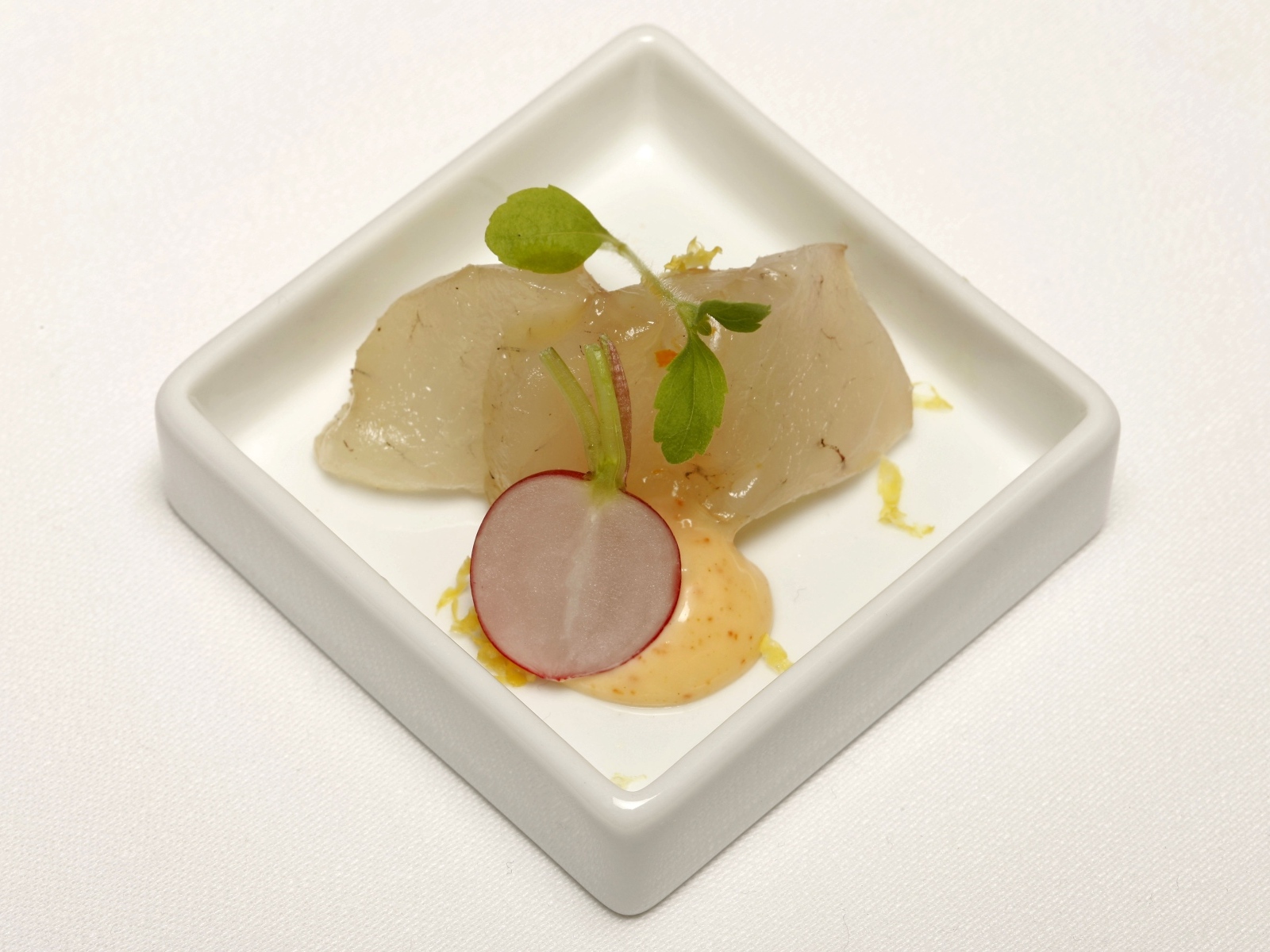 Кусочки сырой рыбы в тарелке с редисом