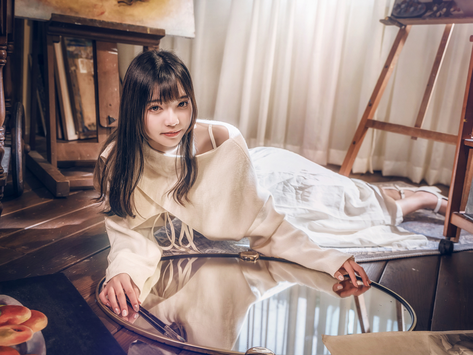 Девушка азиатка в белом платье лежит на полу