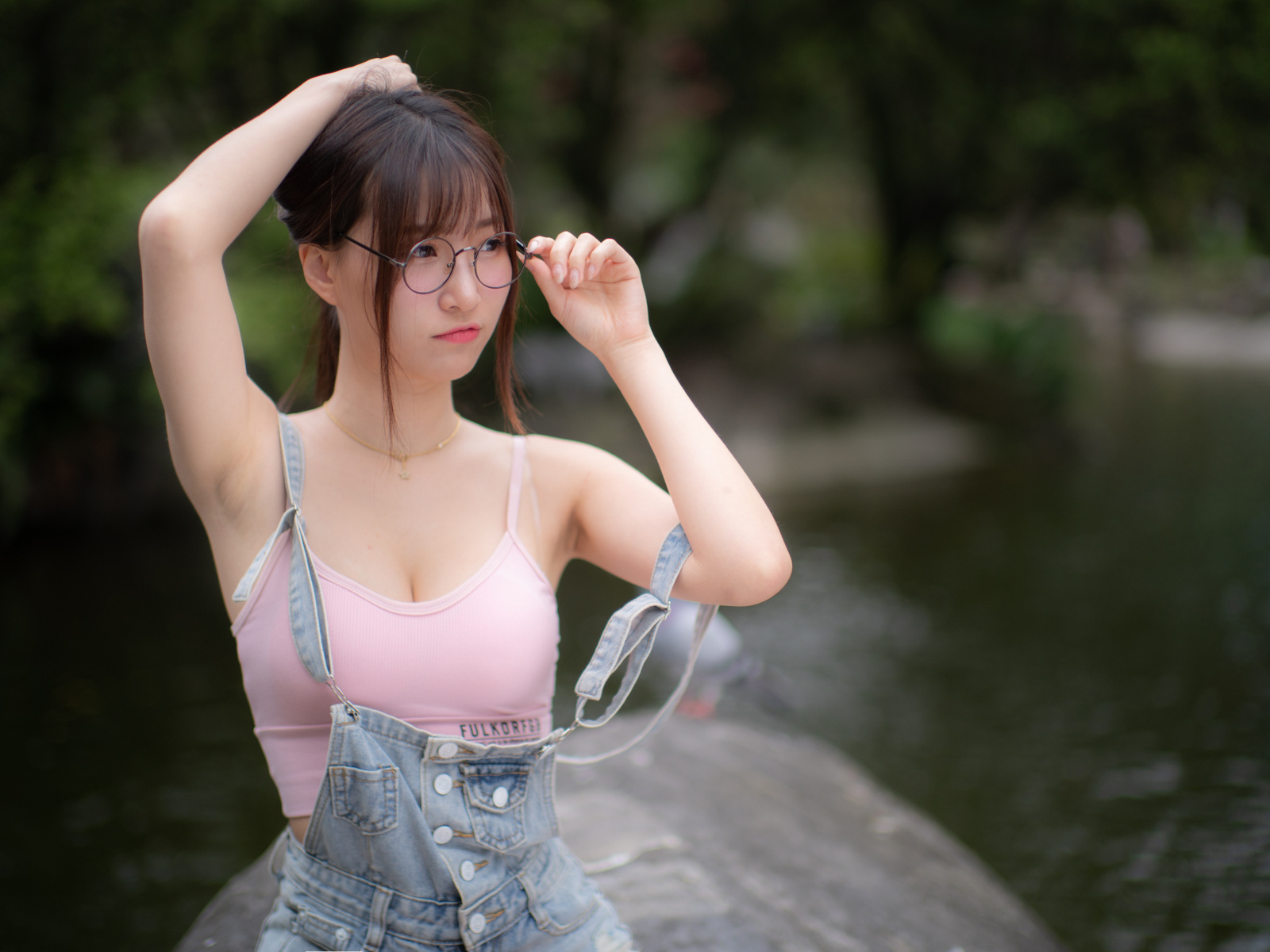 Девушка азиатка в очках и джинсовом комбинезоне