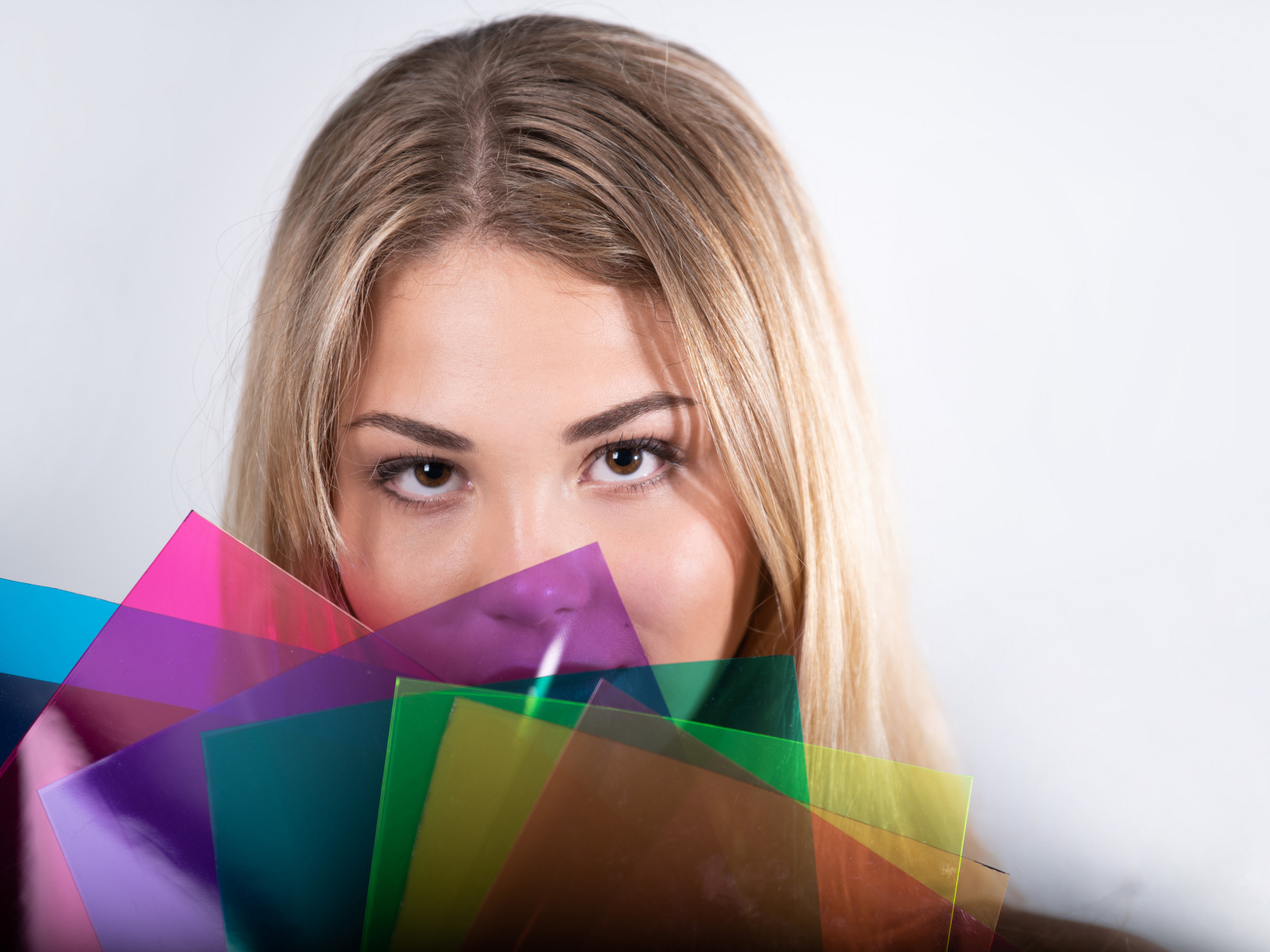 Красивая кареглазая девушка с разноцветной бумагой