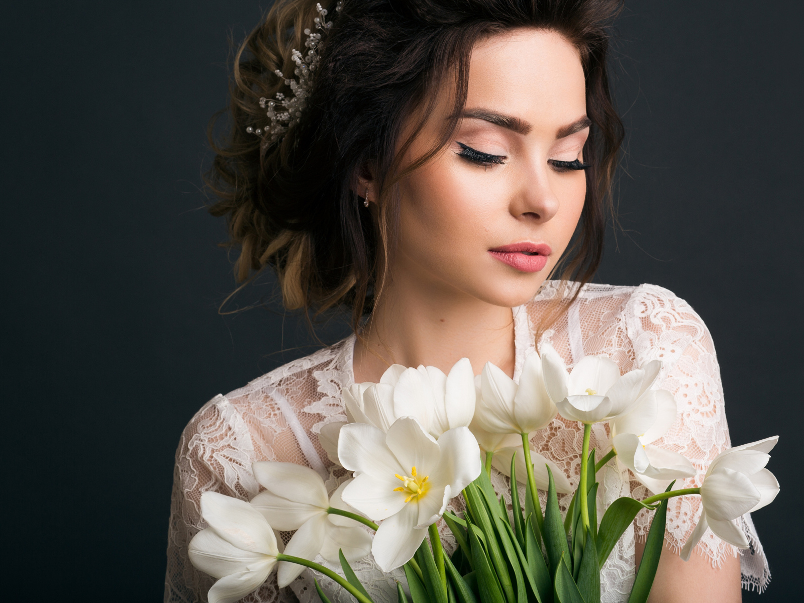 Красивая девушка с букетом белых тюльпанов на сером фоне