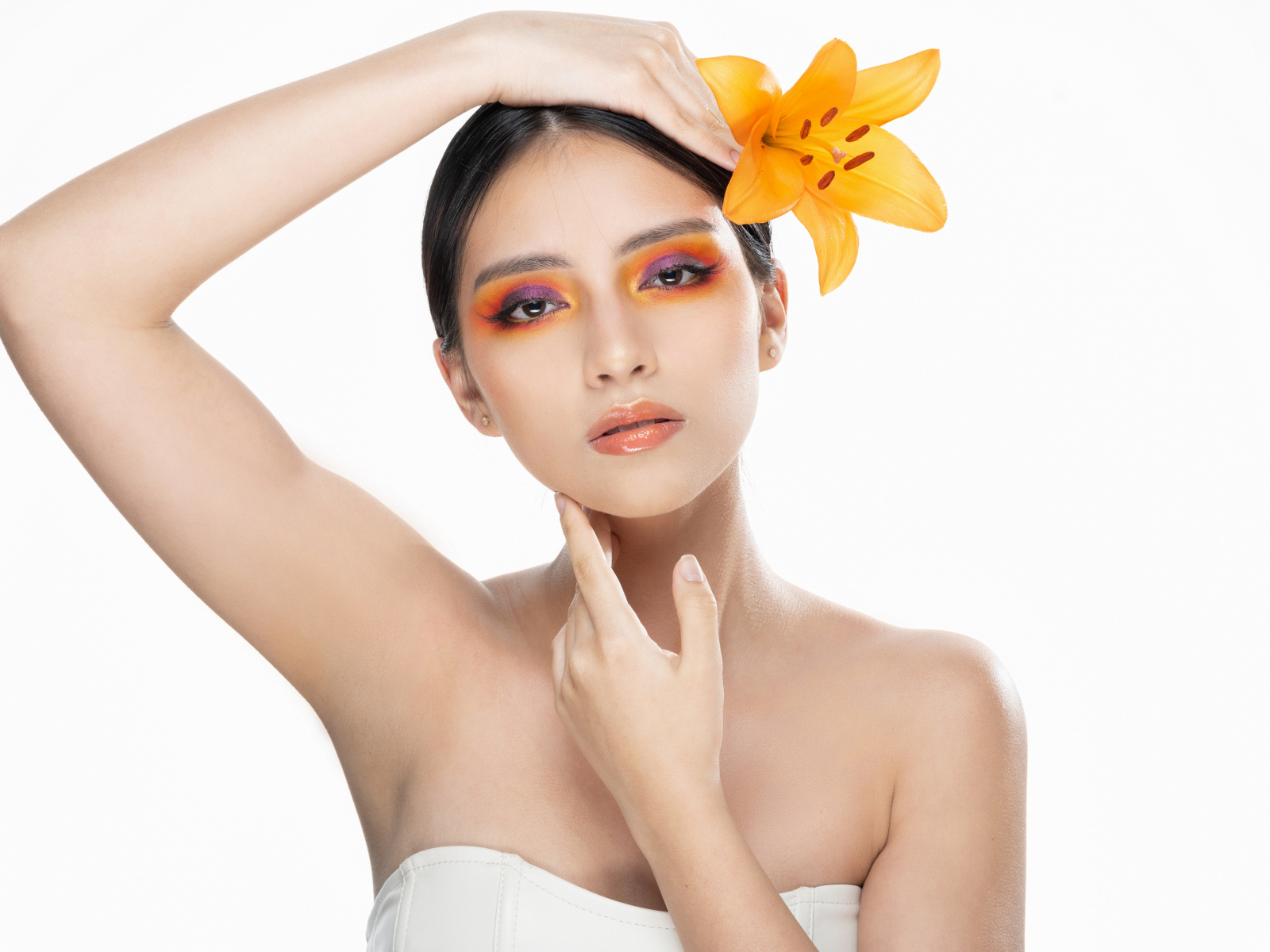 Красивая девушка с цветком лилии в волосах на белом фоне