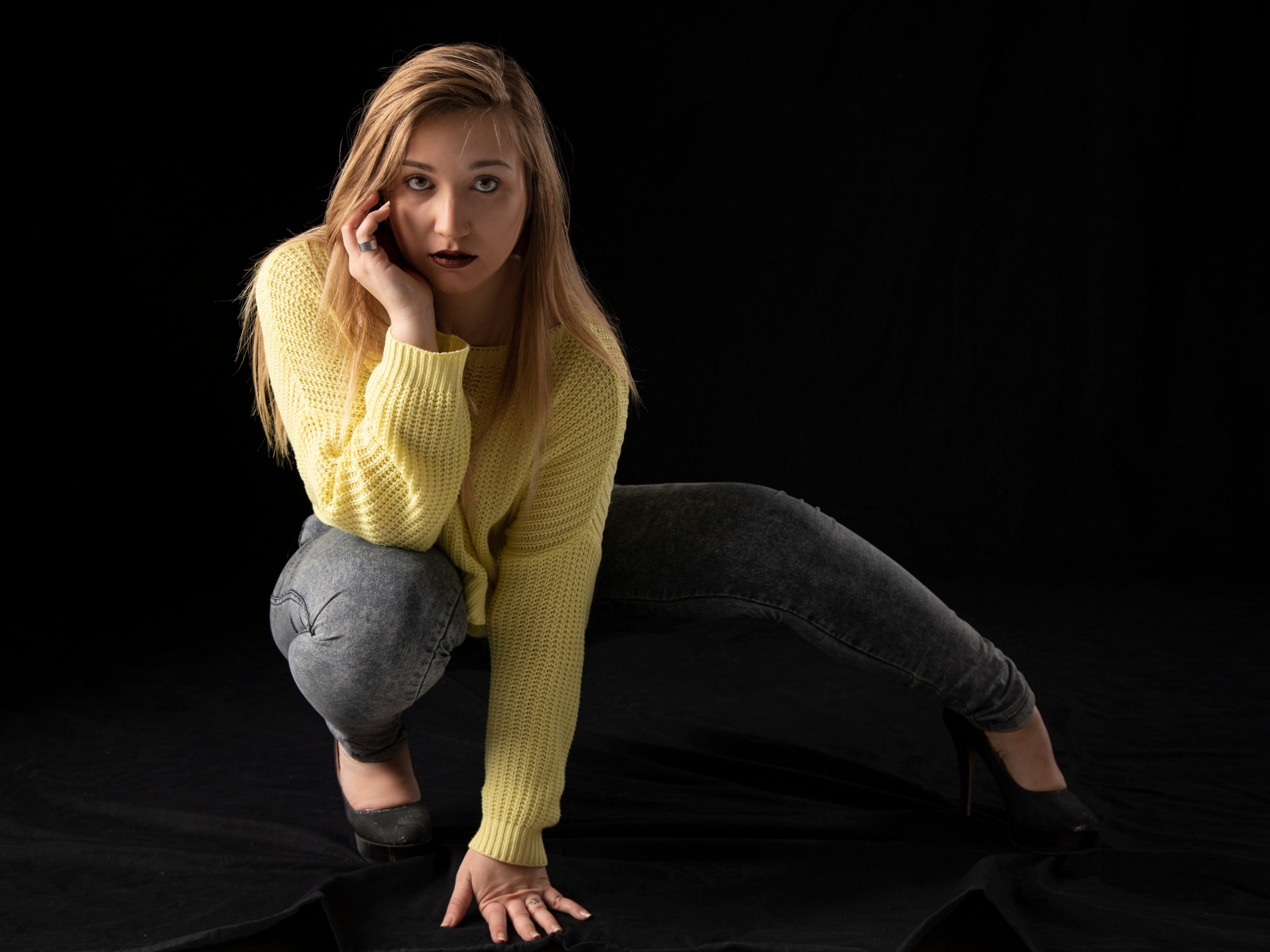 Девушка в желтом свитере на черном фоне