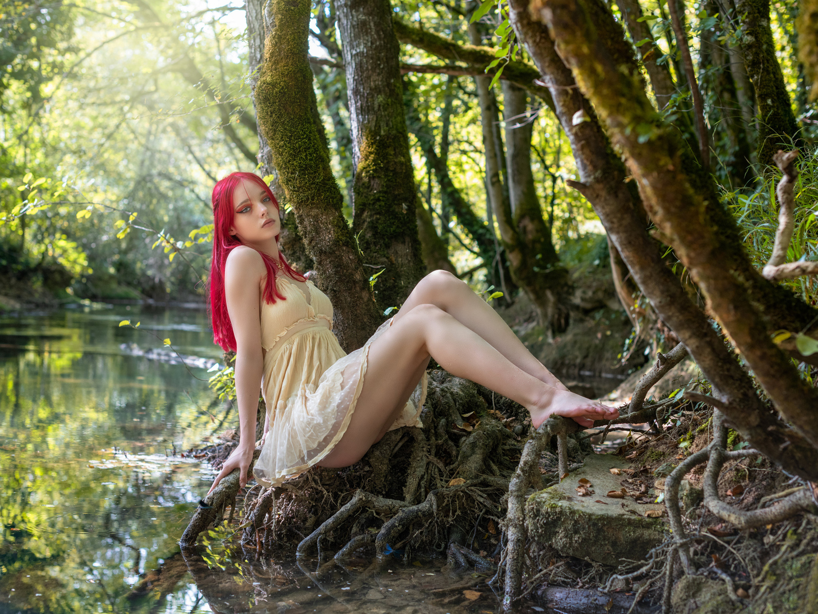 Девушка с розовыми волосами у пруда в лесу