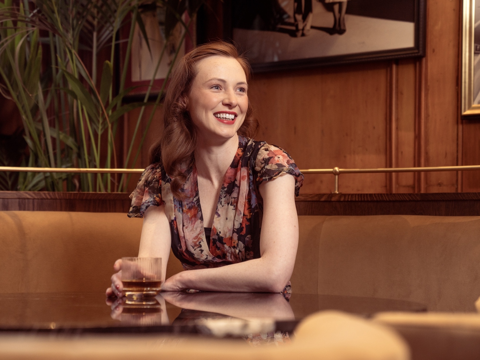 Улыбающаяся девушка за столиком в кафе