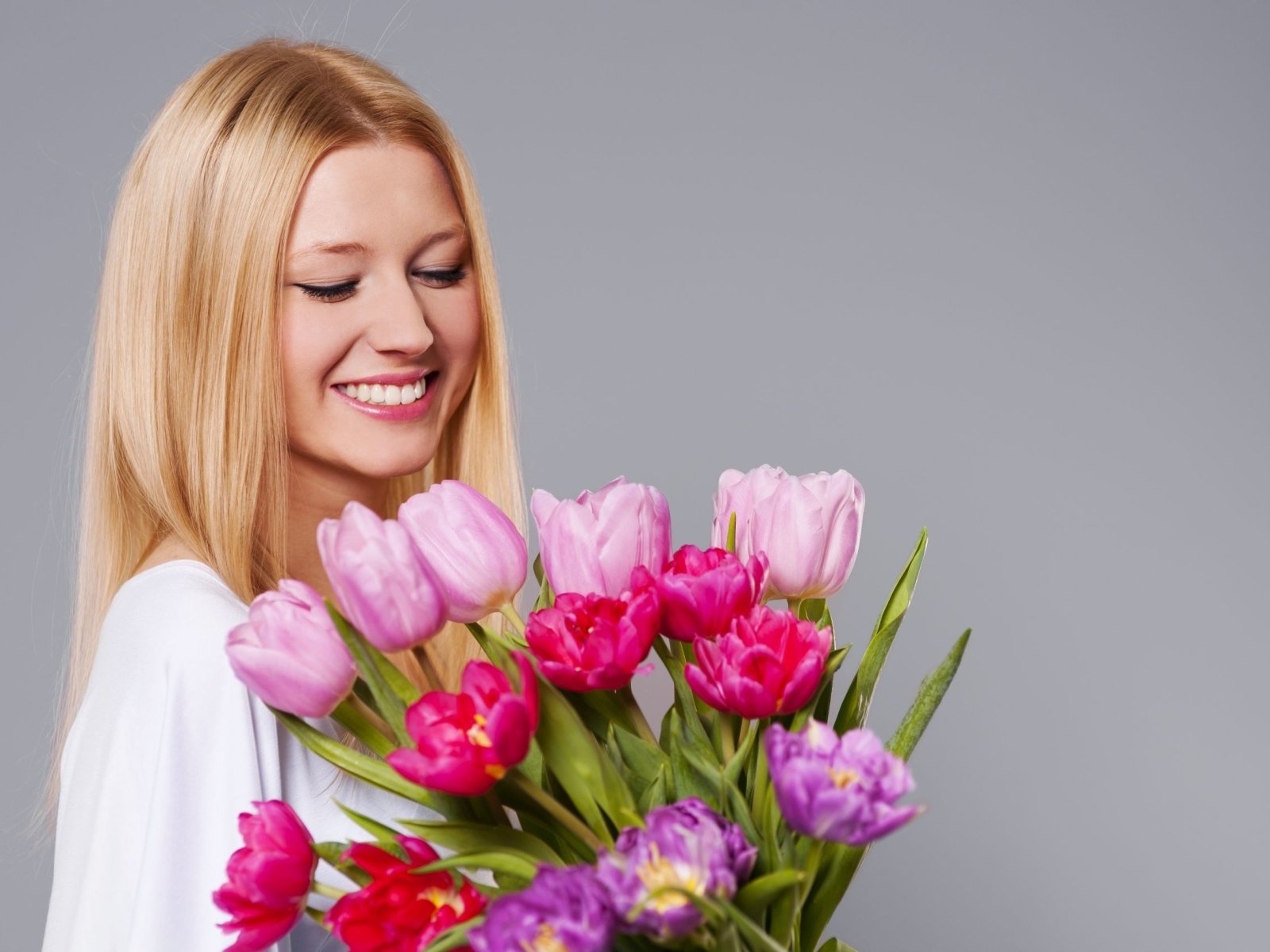 Улыбающаяся девушка с букетом тюльпанов