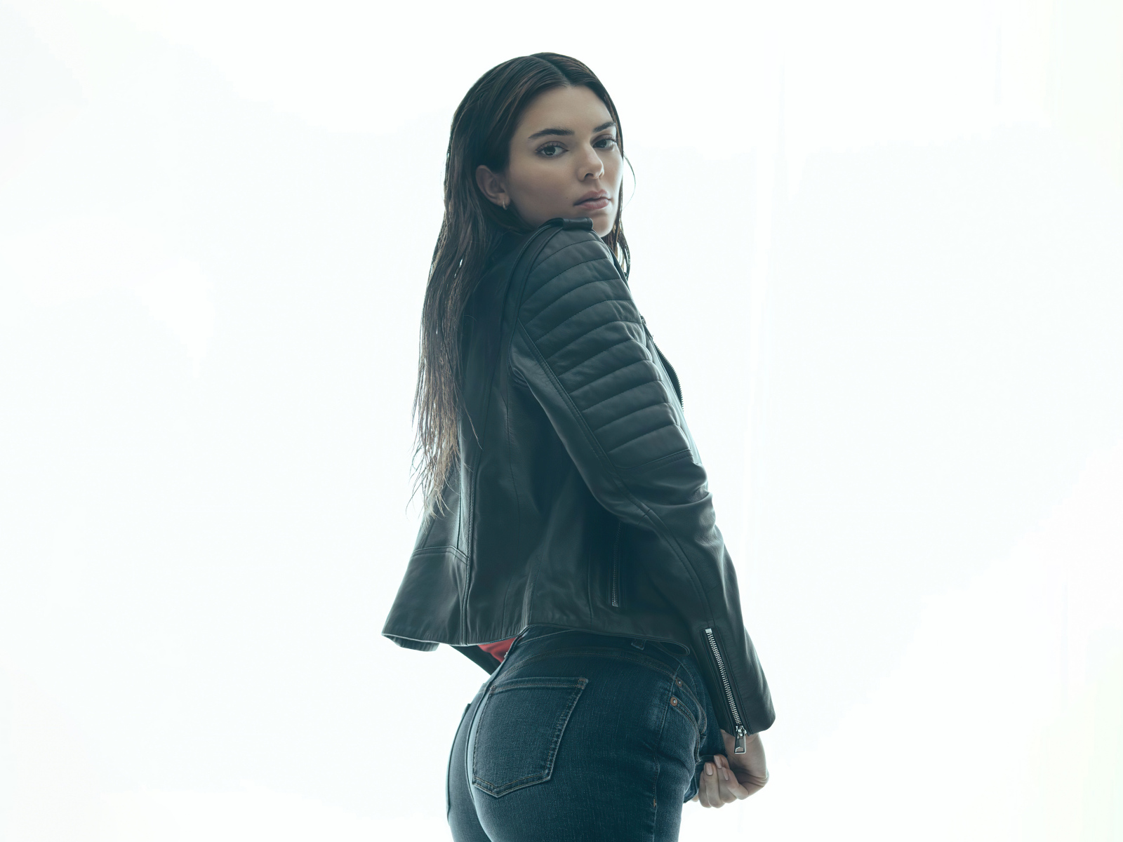 Модель Кендалл Дженнер в черной куртке на белом фоне