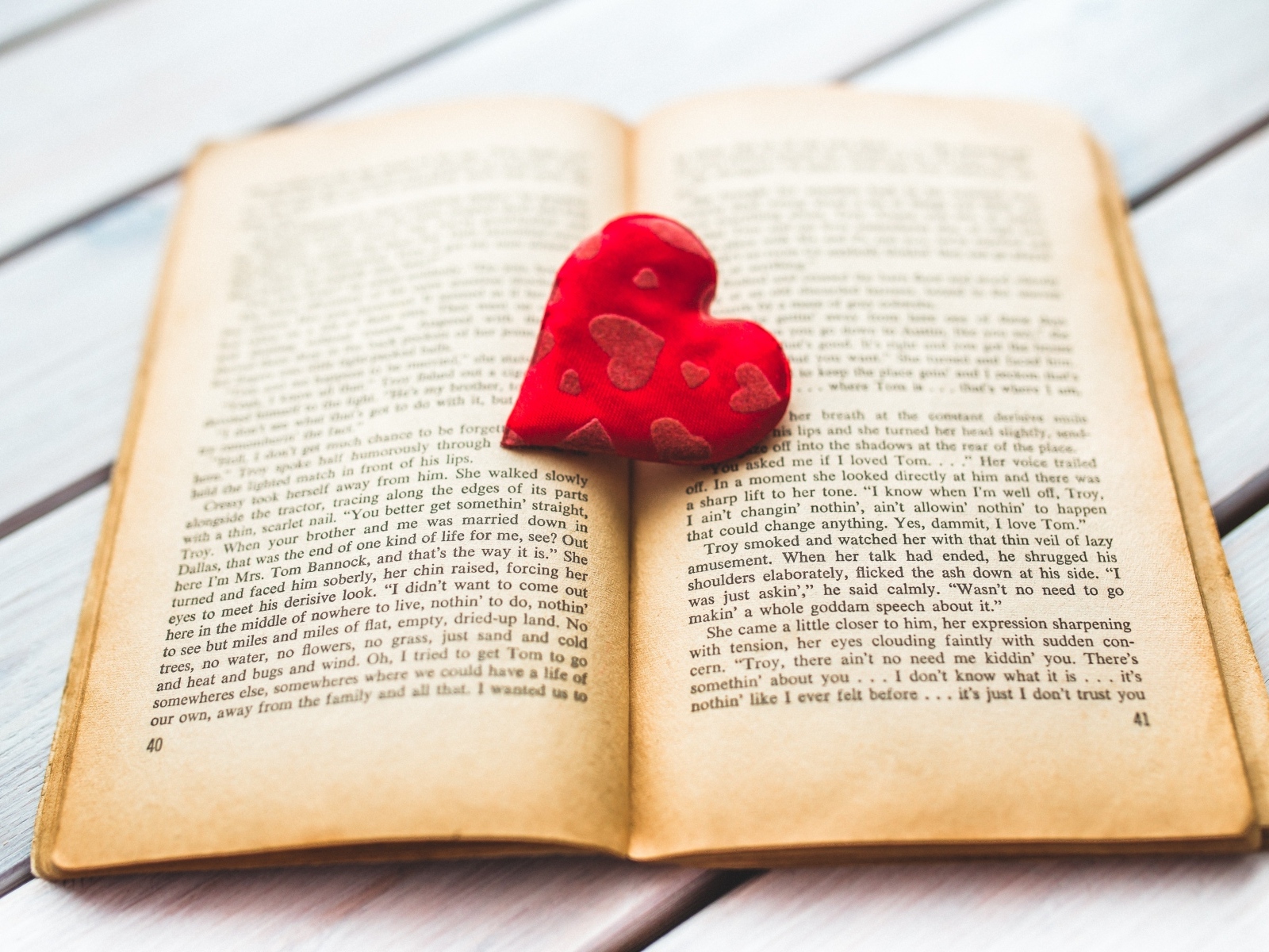 Маленькое красное сердце с книгой на столе