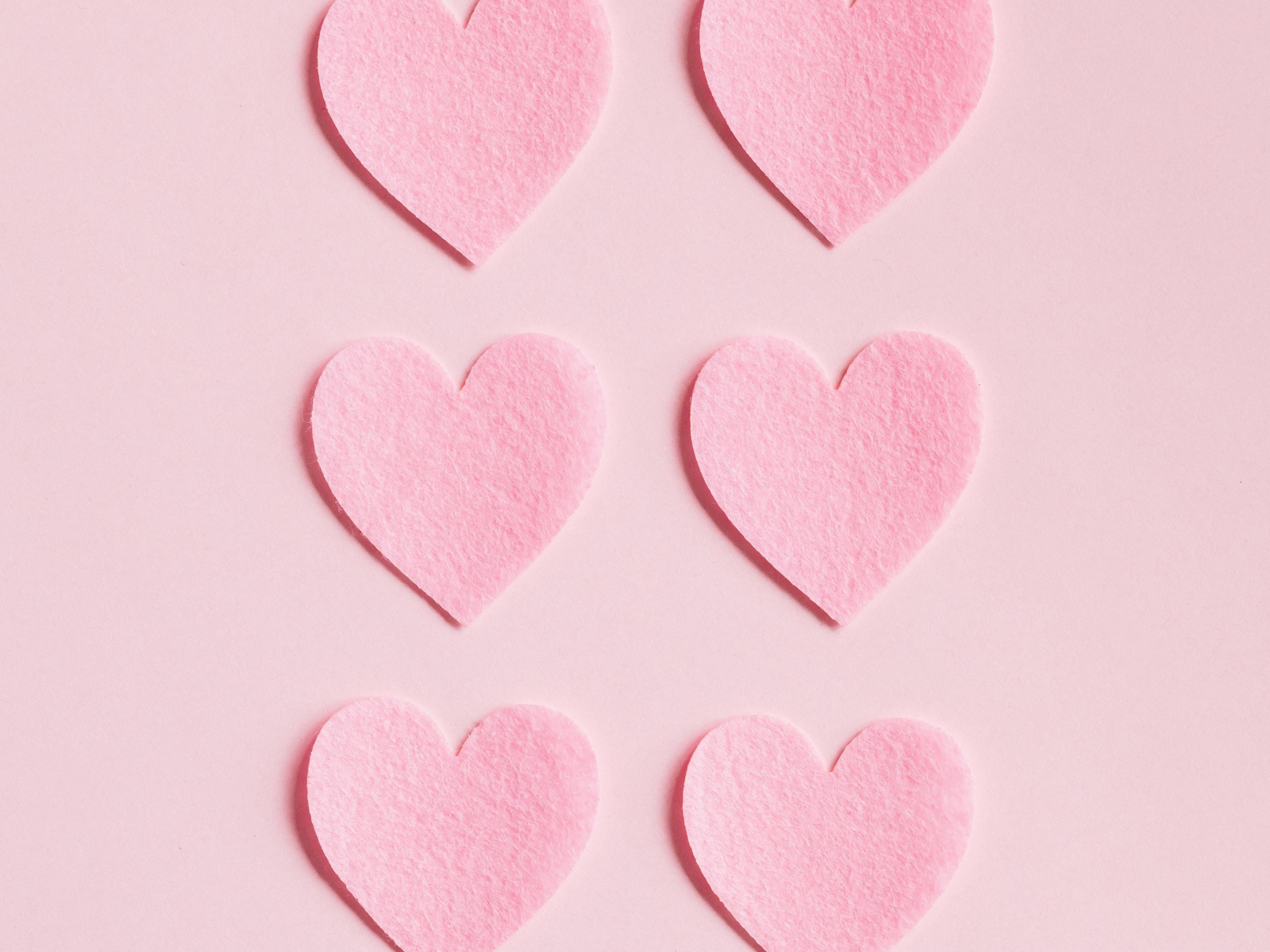 Маленькие бумажные сердечки на розовом фоне