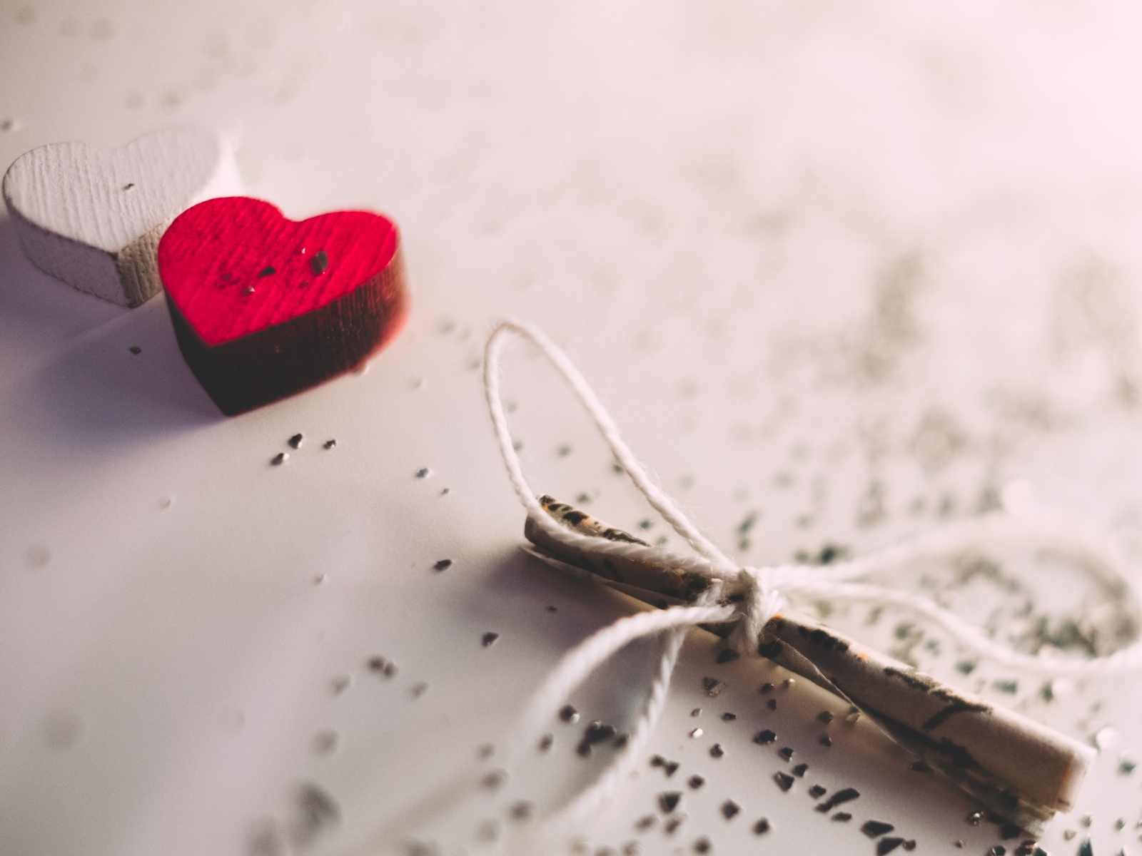 Два деревянных сердечка с запиской на столе