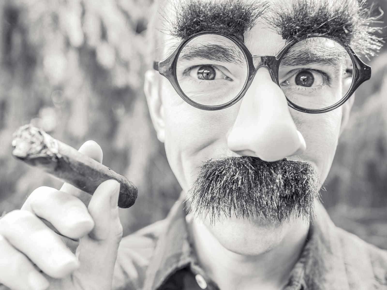 Мужчина в очках с сигарой в руке