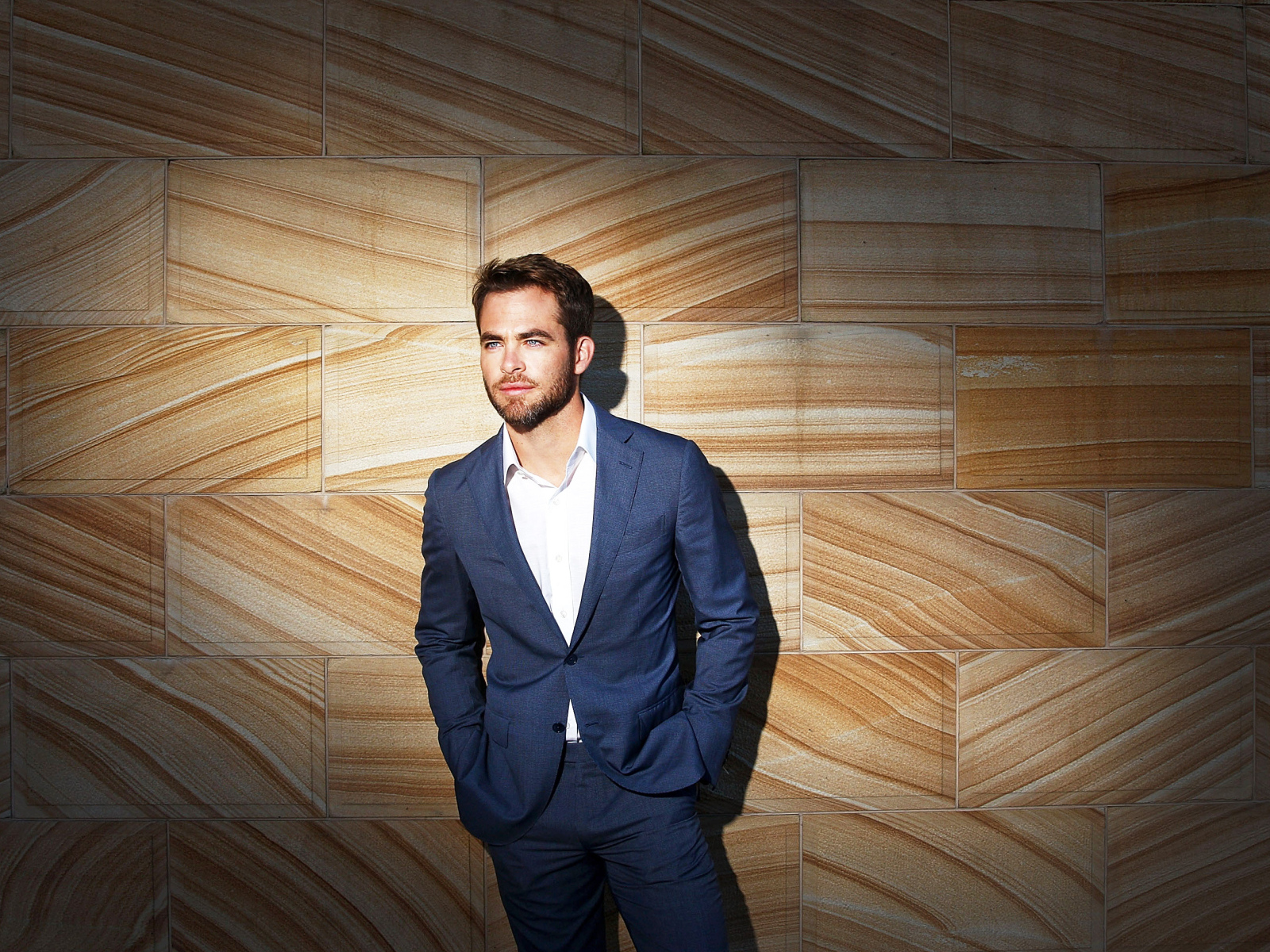 Американский актер Крис Пайн в костюме у стены