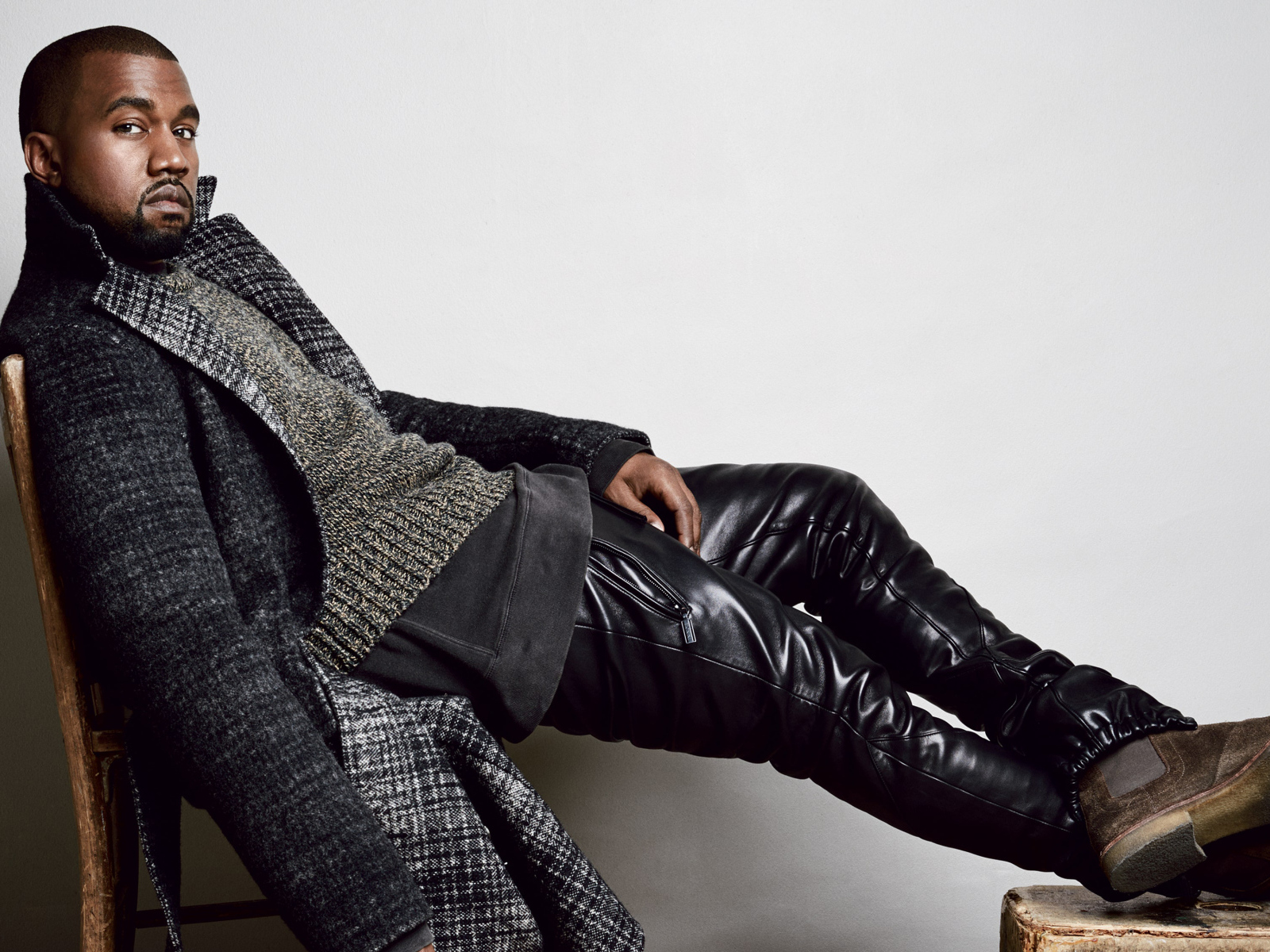 Рэпер Канье Уэст сидит на стуле