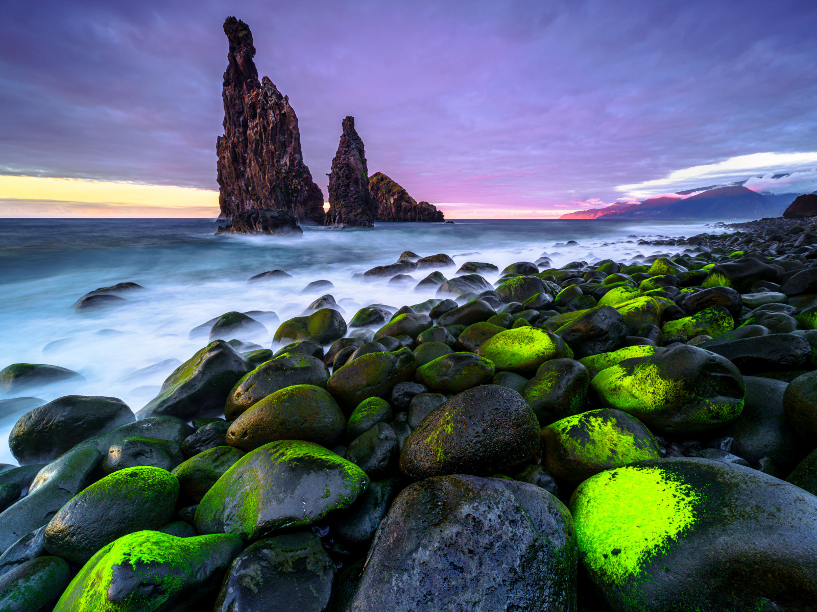 Большие черные камни лежат на берегу острова Мадейра